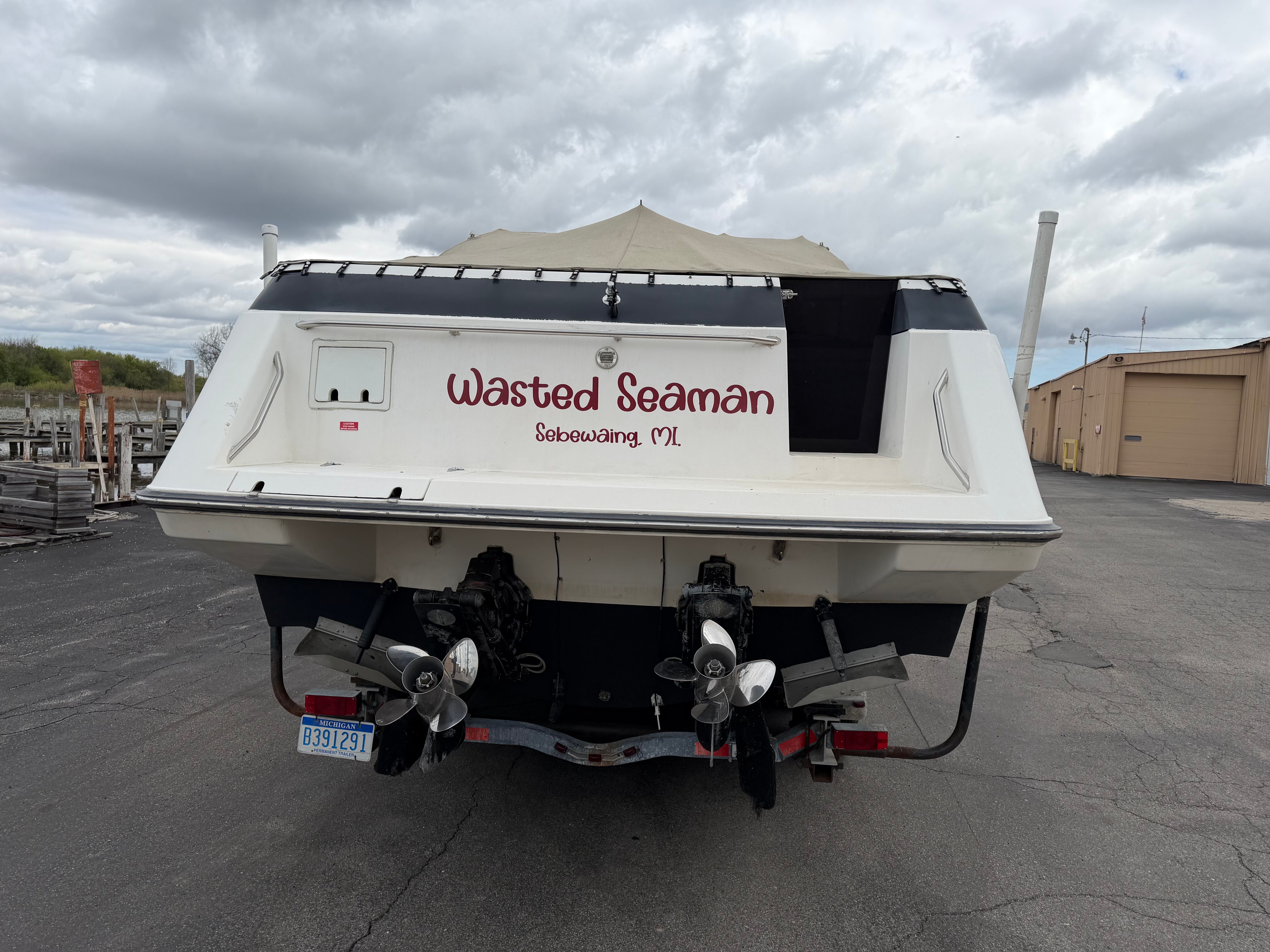Rear view of a 1990 Chaparral Signature 30 boat on a parking lot.