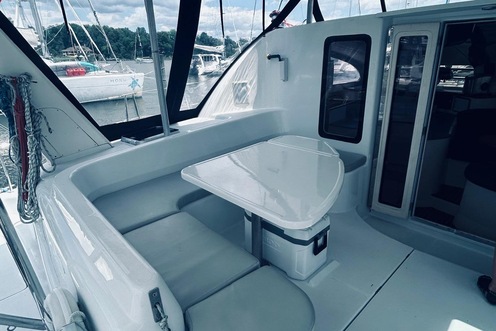 2001 Robertson & Caine Leopard yacht interior with seating and table, docked at marina.