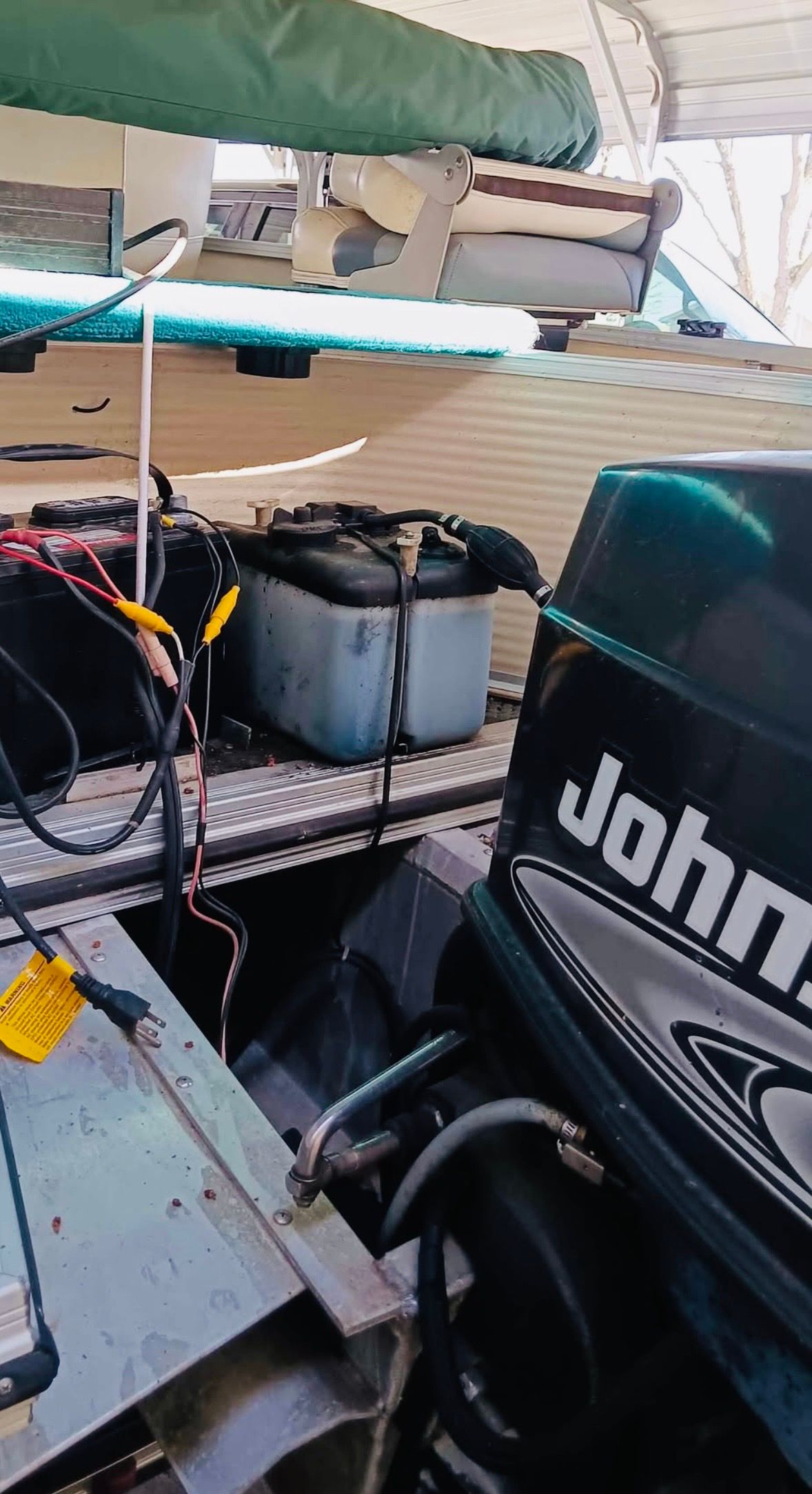 A 2001 Lowe Trinidad 204 with a Johnson outboard motor and batteries in the stern area.