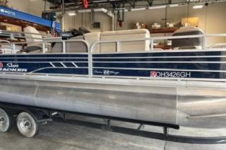 2022 Sun Tracker Fishin' Barge 22 DLX pontoon boat on trailer in warehouse.