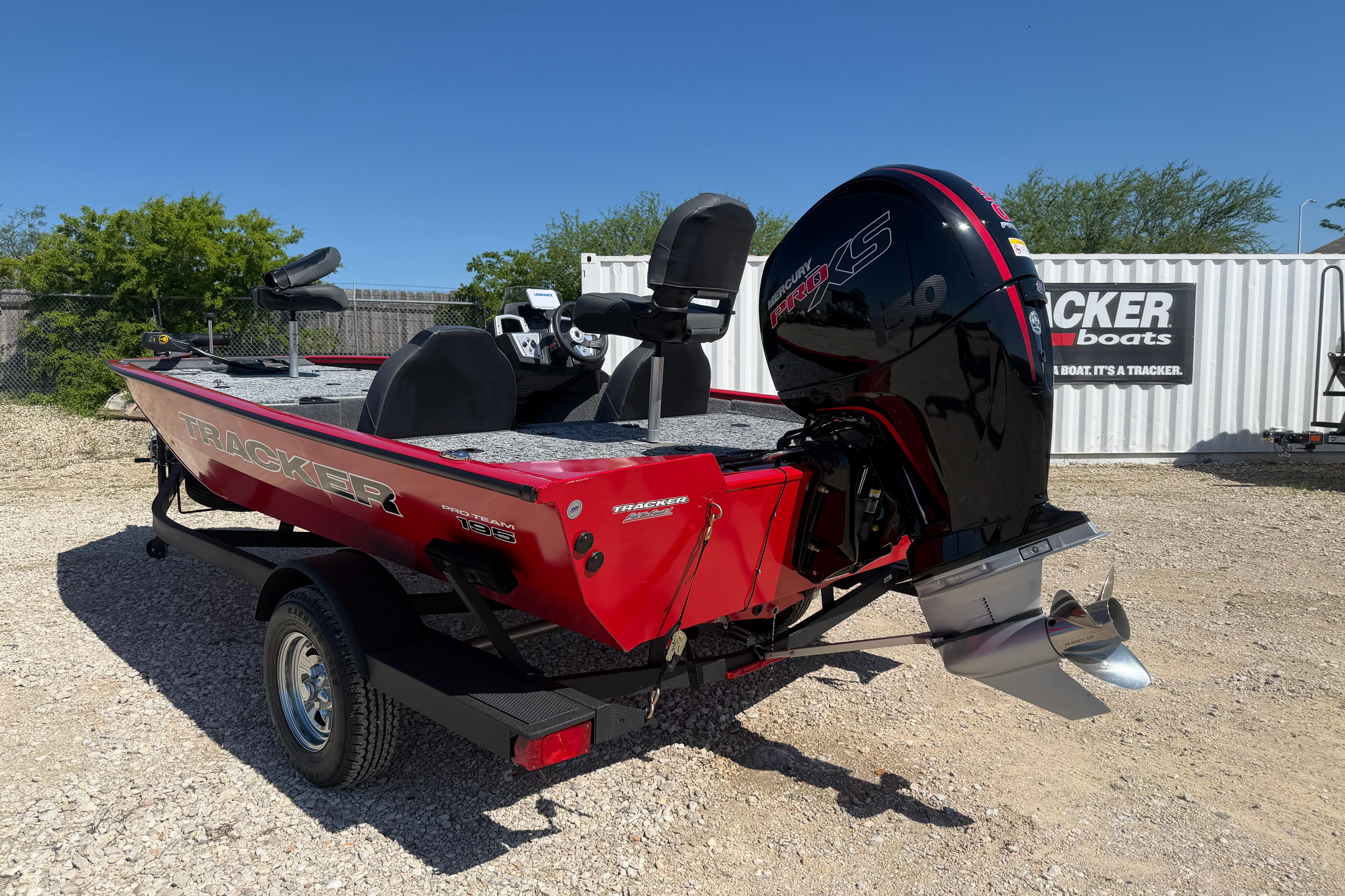 2026 Tracker Pro Team 195 boat with Mercury engine, parked outdoors on gravel.