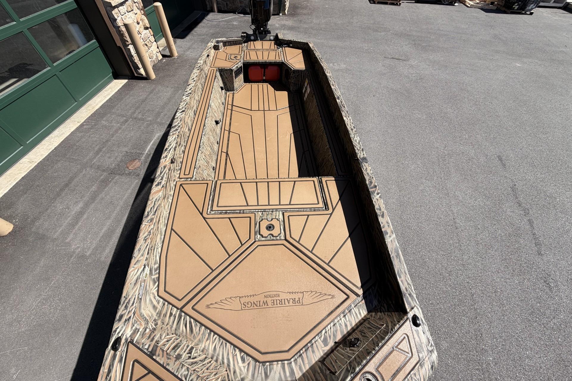 2026 Tracker Grizzly 1650 T Prairie Wings Edition boat with camouflage design on pavement.