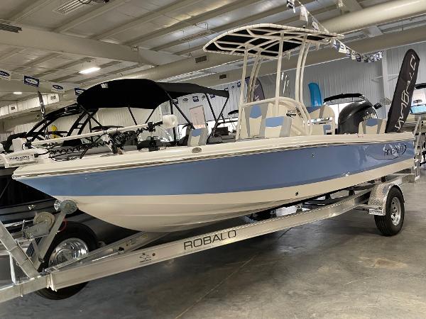 2025 Robalo 206 Cayman boat in showroom, blue and white design on trailer.