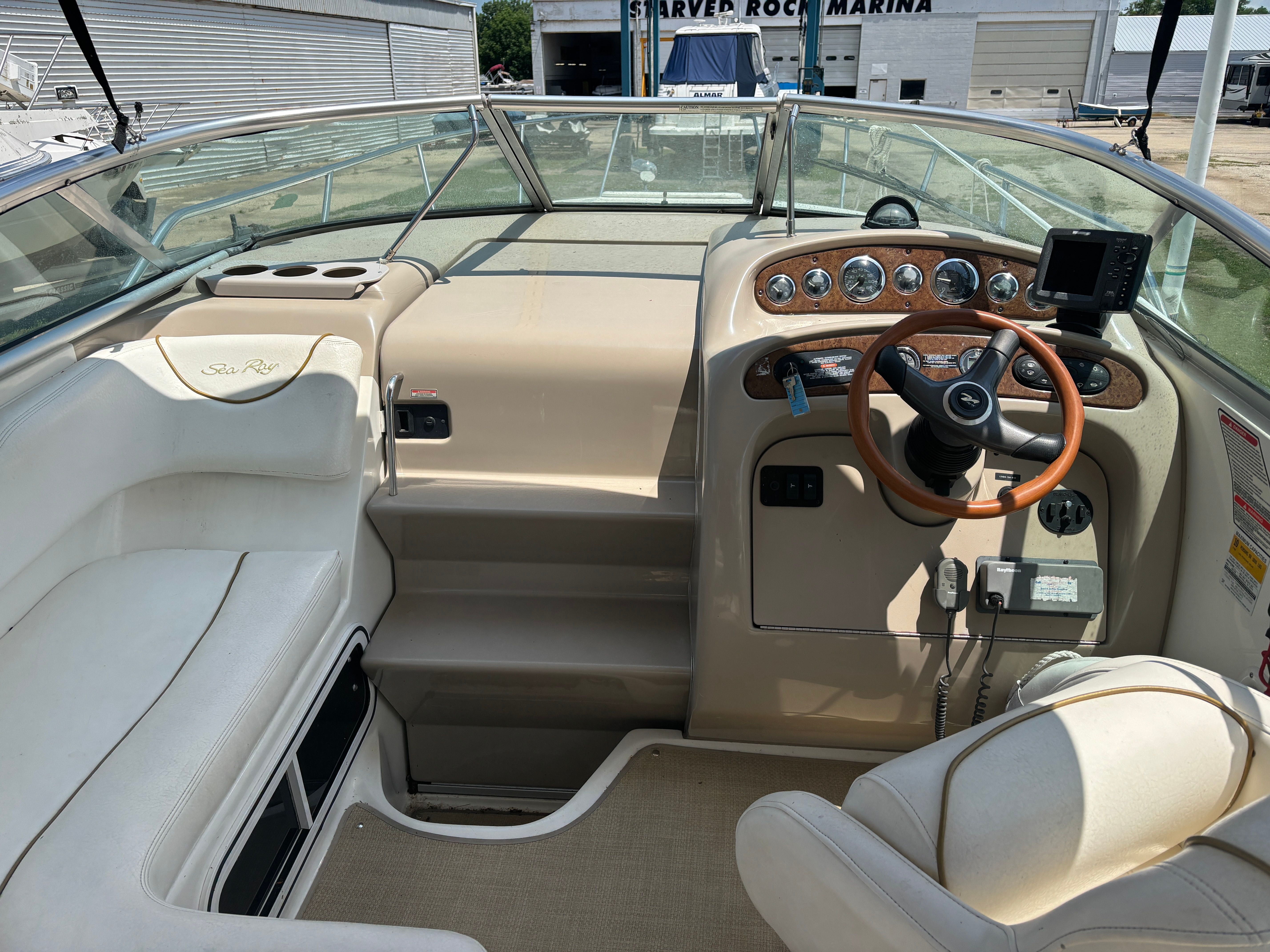 The image shows the cockpit of a 2000 Sea Ray Sundancer 260 with an elegant helm station.