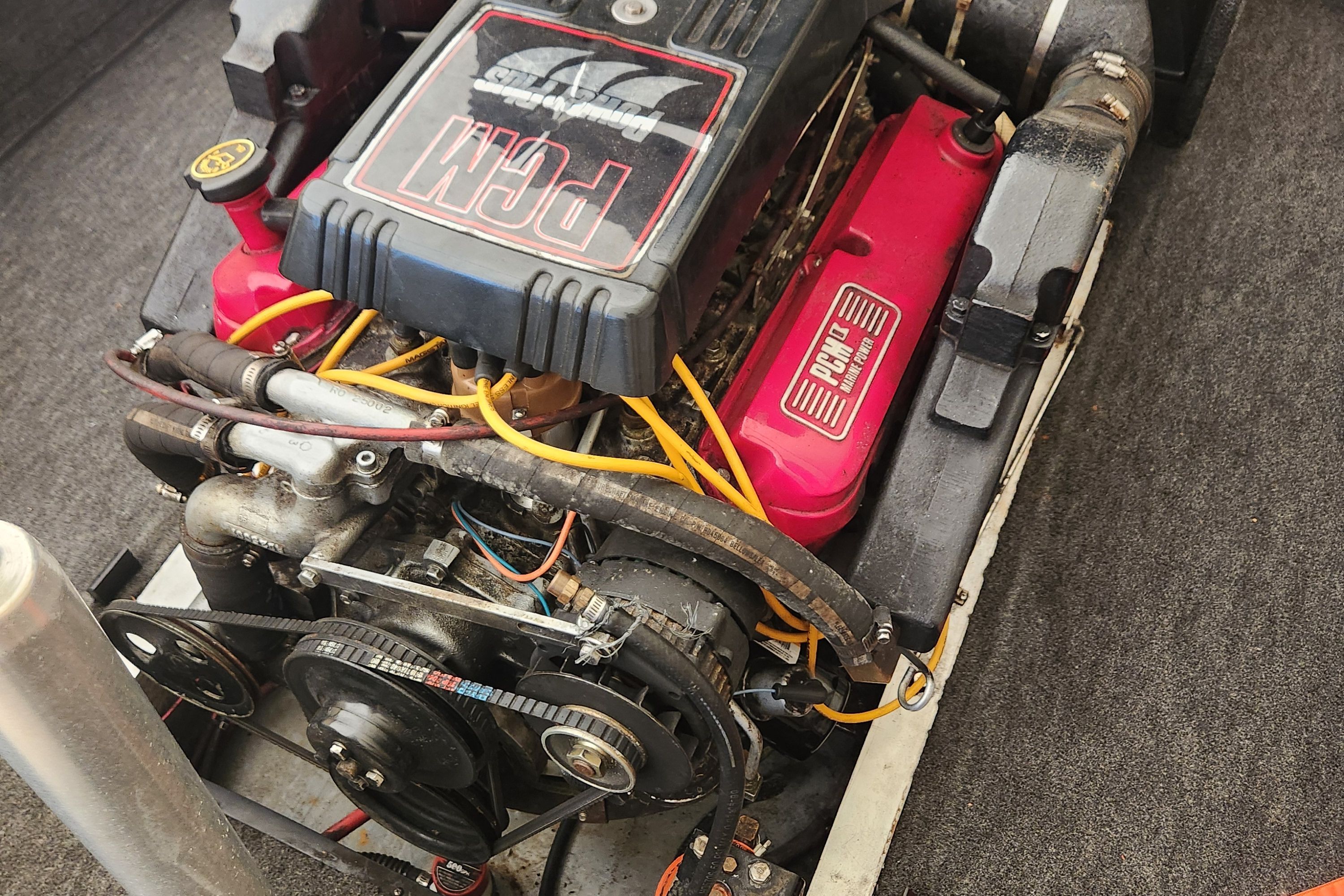 Engine of a 1991 Correct Craft Sea Nautique with red covers and yellow wires.