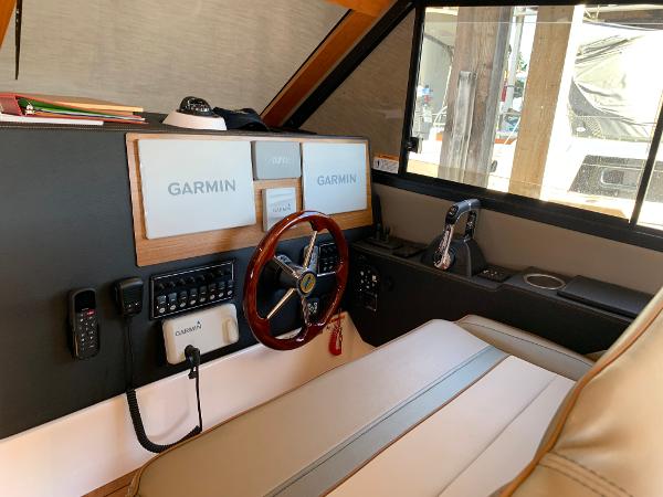 2021 Cutwater C-32 CB helm with Garmin navigation, steering wheel, and control panel.