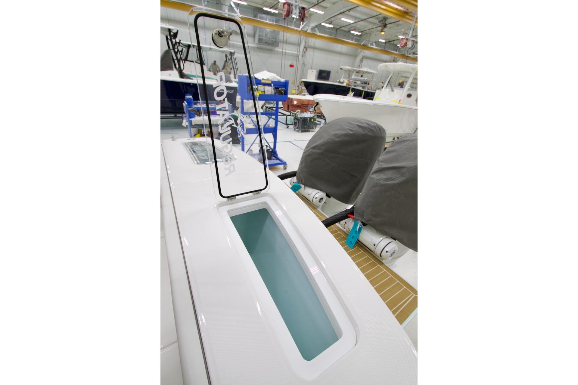 2026 Regulator 31 boat interior with livewell and covered engines in a showroom.