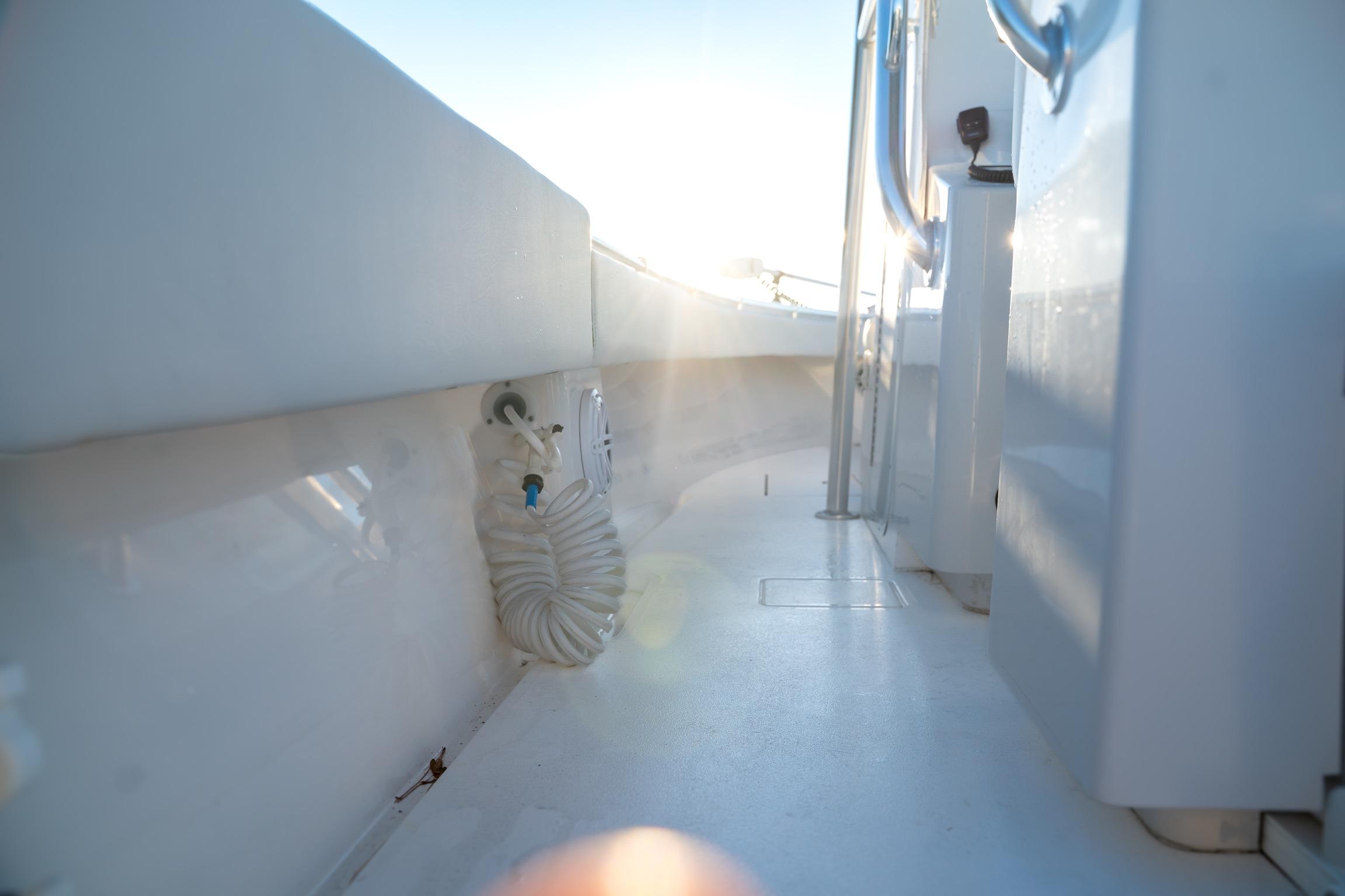 2020 Contender 32 ST boat interior with coiled hose and sunlight.