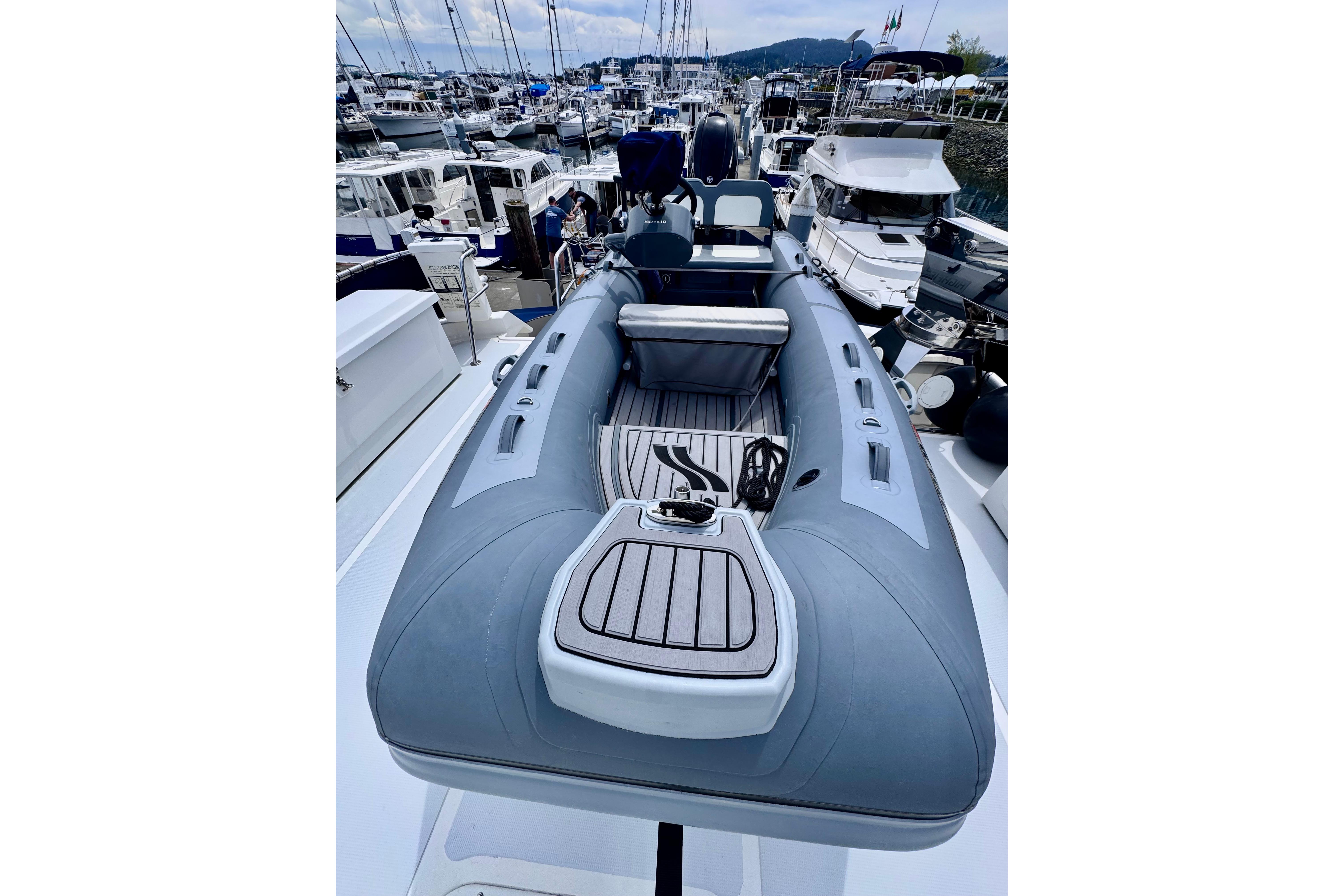 Inflatable boat on Nordhavn 50 yacht, 2000 model, docked at marina with other vessels.