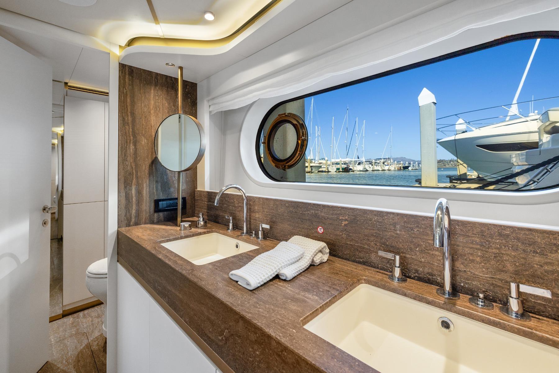 Luxurious bathroom interior on 2026 Azimut Magellano 25M yacht with marina view.