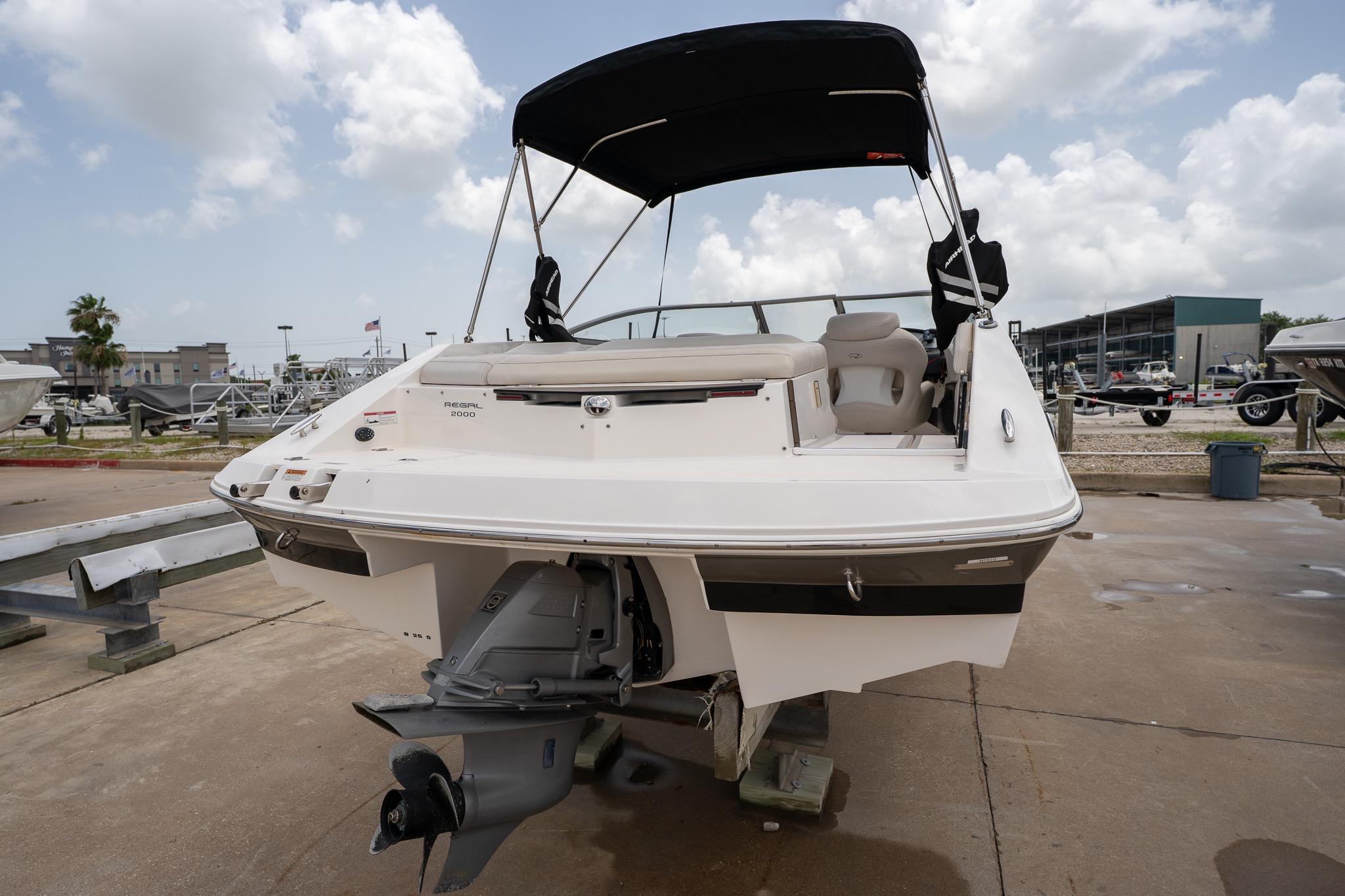 2008 Regal 2000 Bowrider boat with canopy, docked on a sunny day.