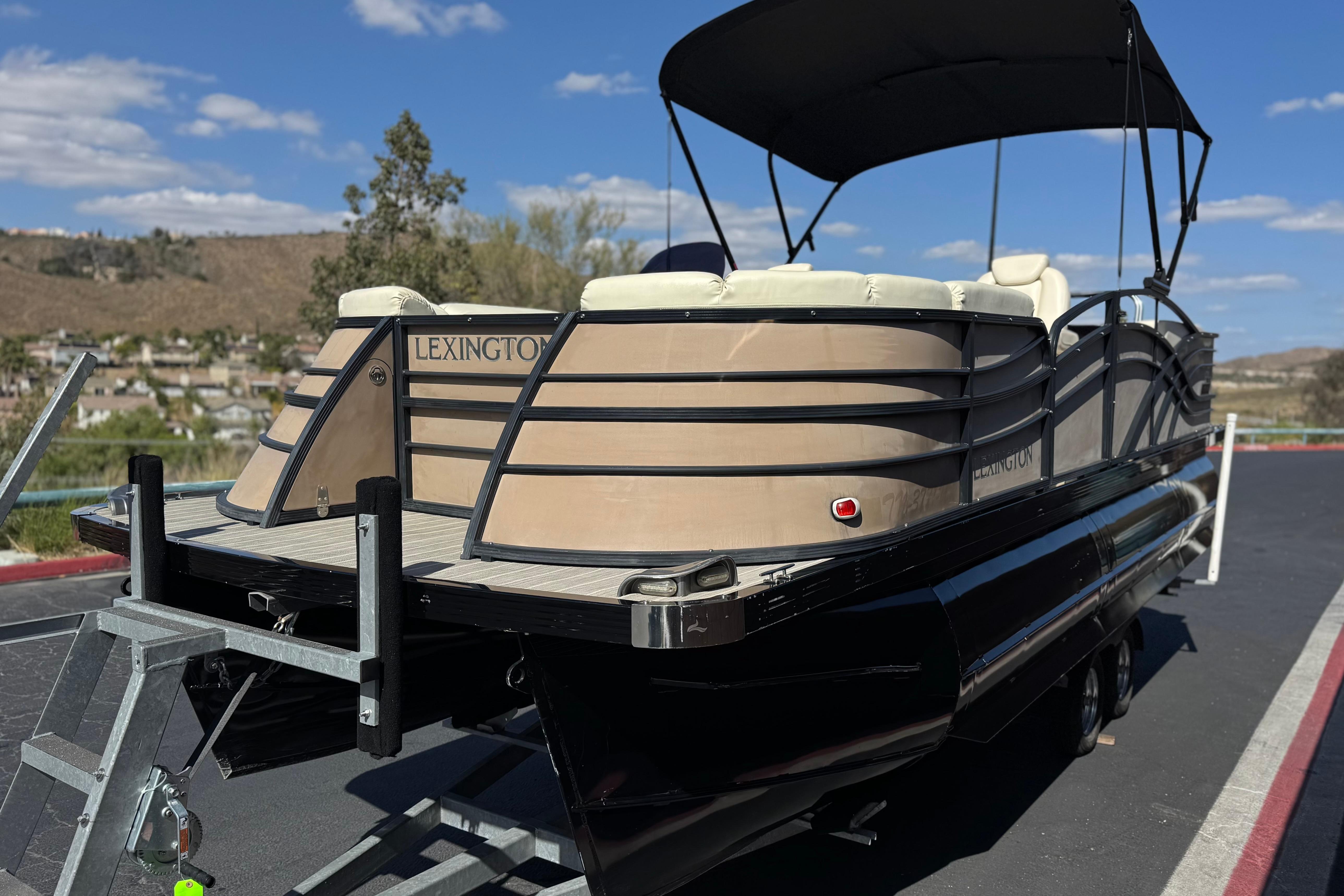 2023 Lexington 623 ST Xtreme pontoon boat on trailer, parked outdoors.