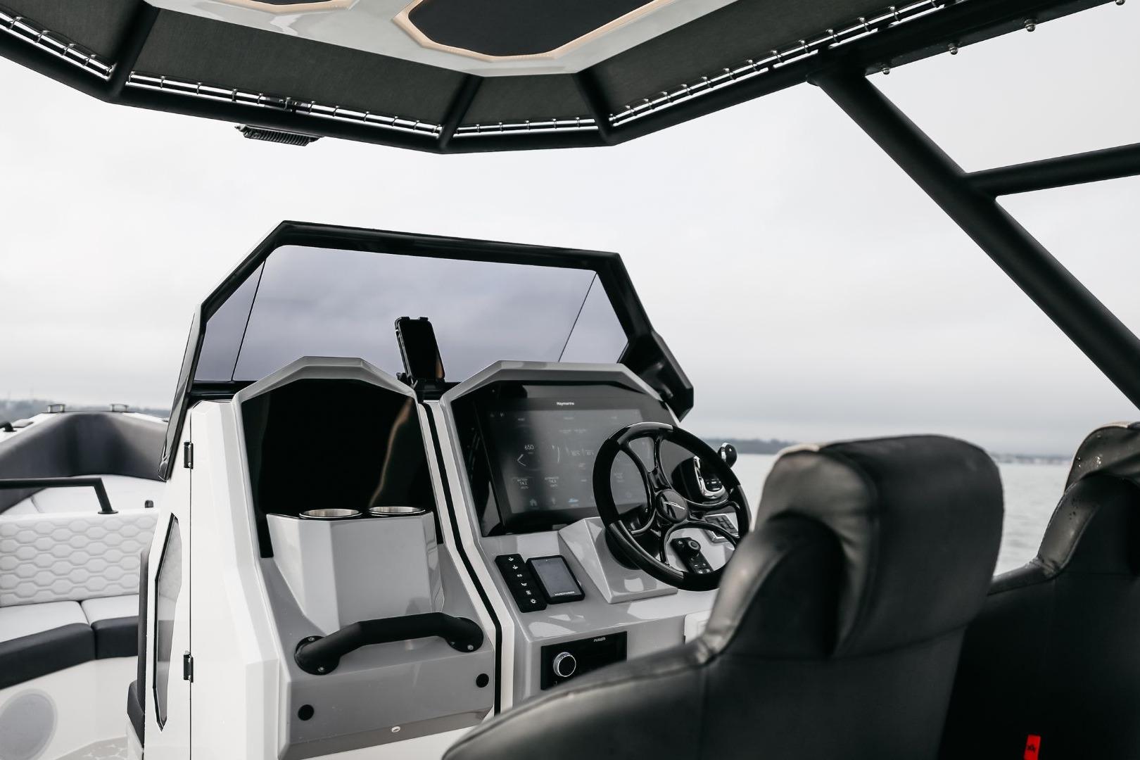 Interior of 2024 Arksen Custom 10.8 boat, featuring modern steering and dashboard controls.