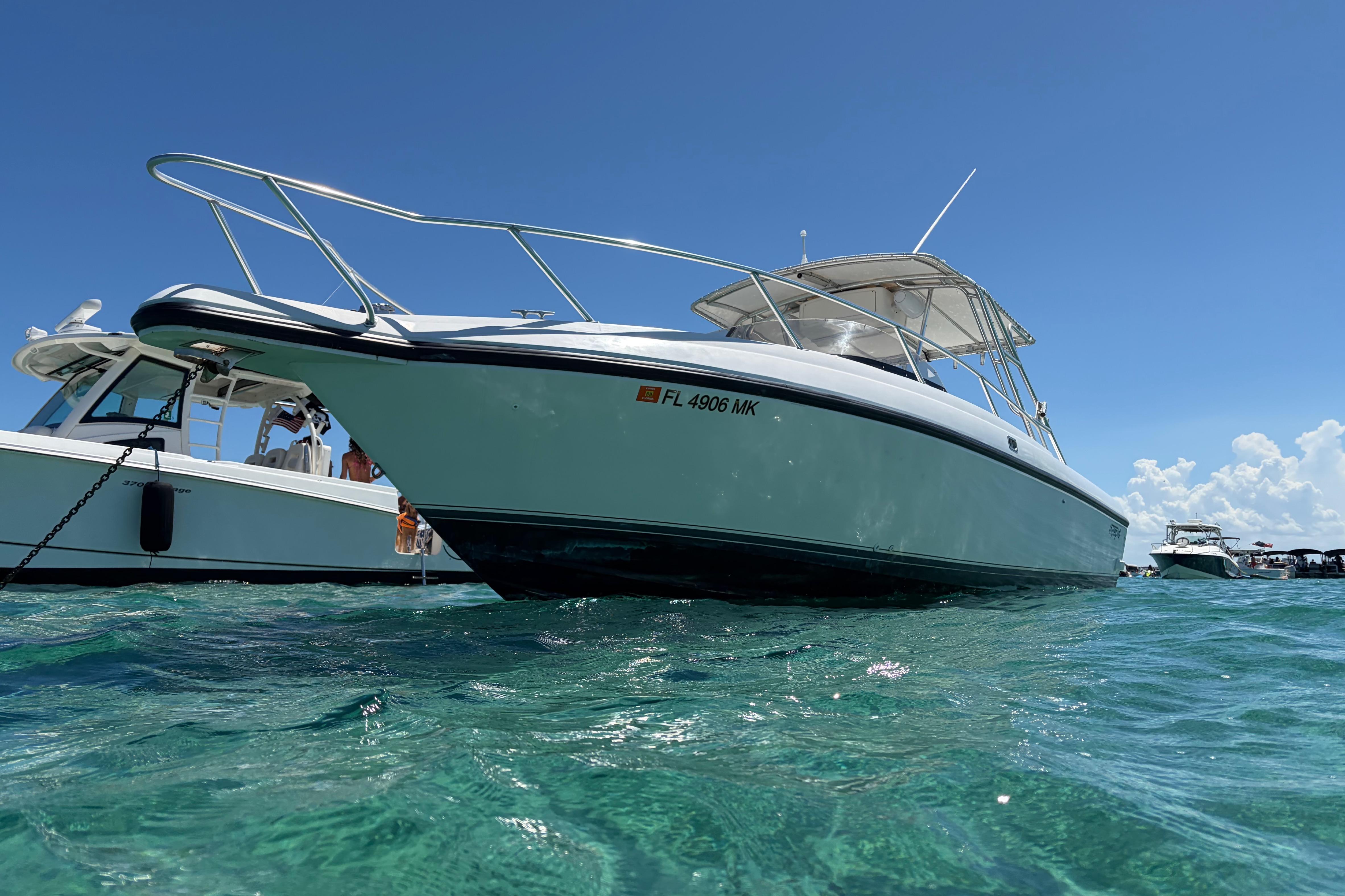 1998 Intrepid 339 Walkaround boat on clear blue water under a sunny sky.