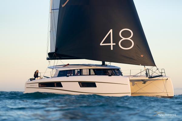 2025 Nautitech 48 Open catamaran sailing on open water with black sail.