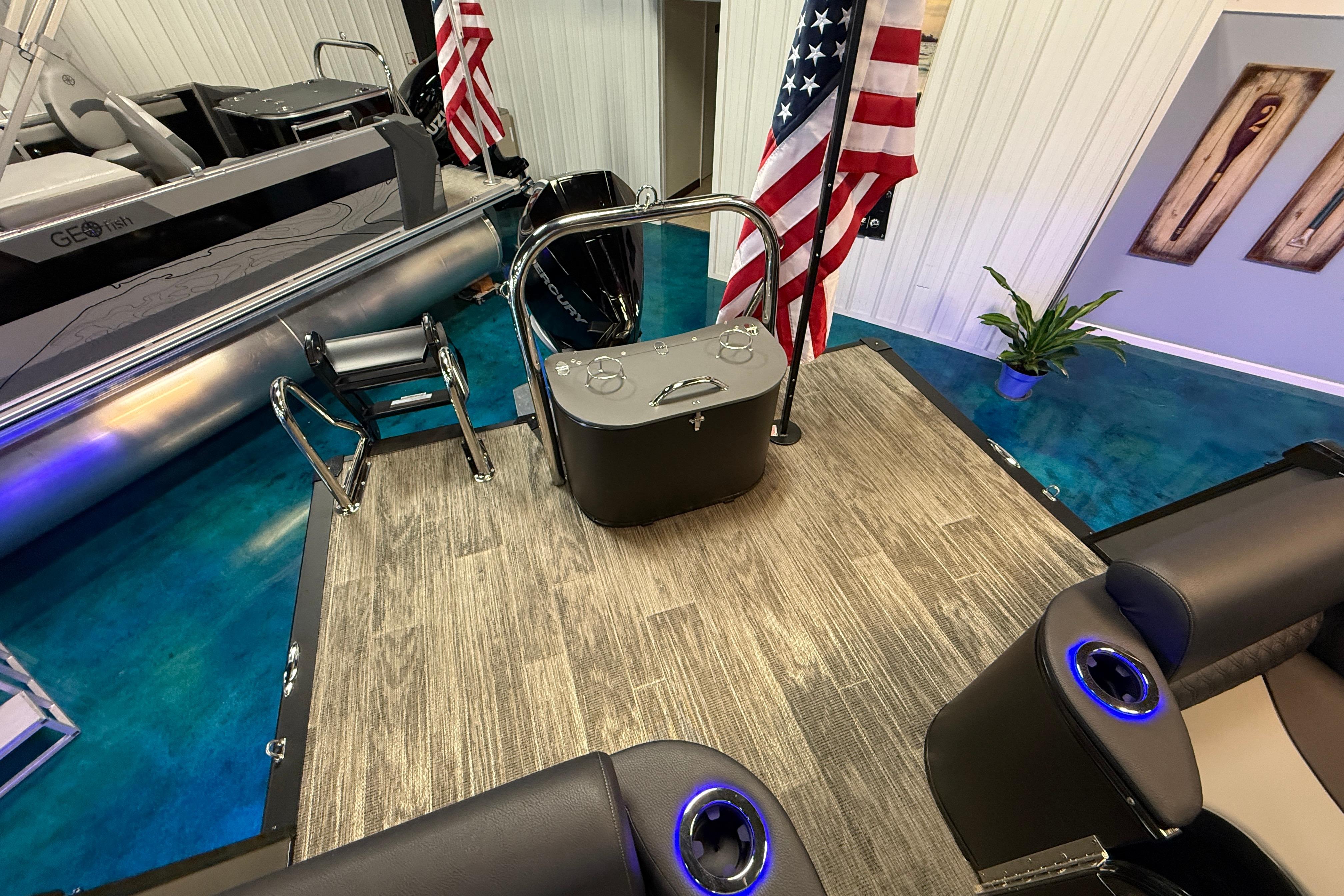 2026 Tahoe Pontoon Cascade Cruise Rear Bench with American flags in showroom.