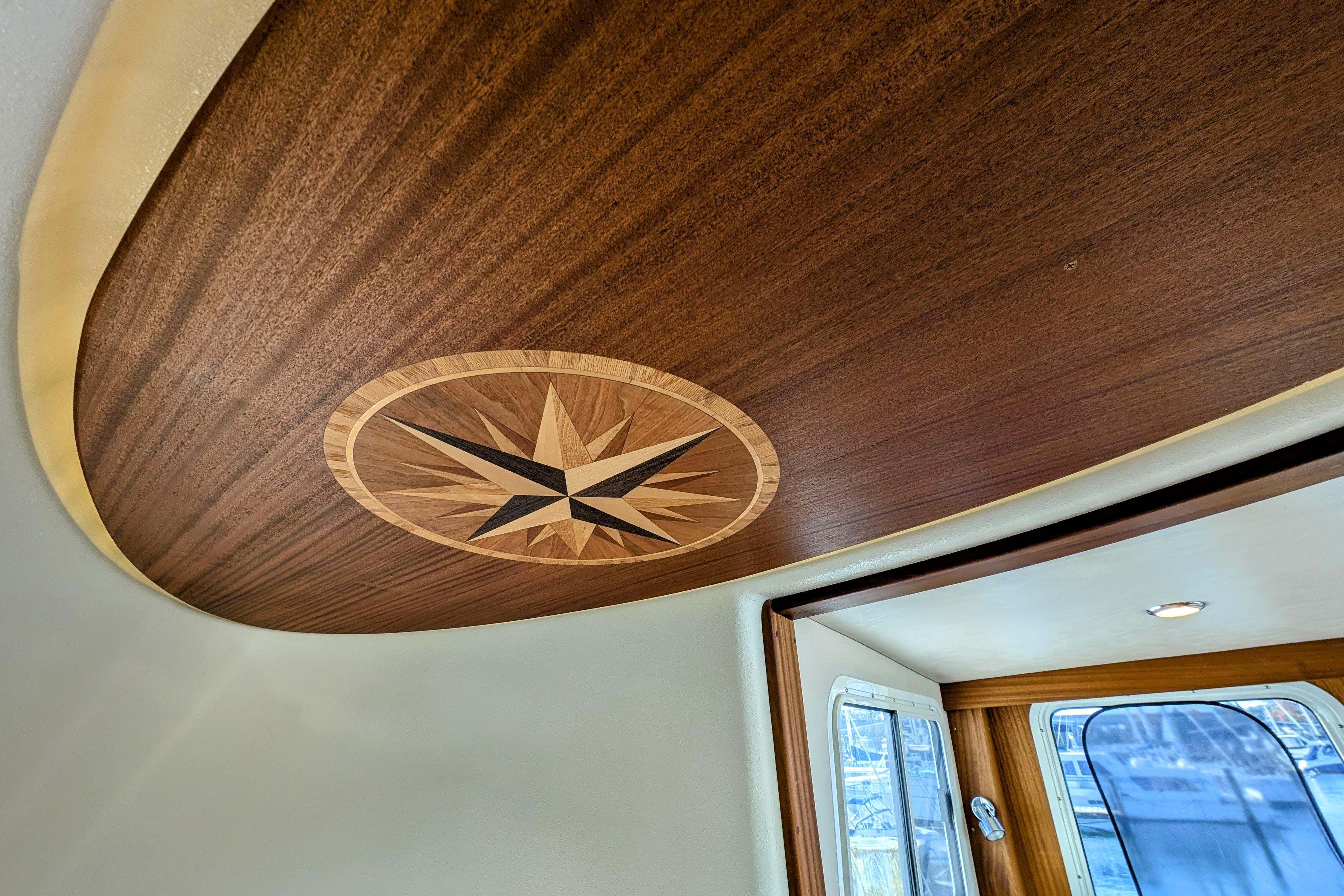 Wooden interior ceiling with compass rose design on 2015 American Tug 435 boat.