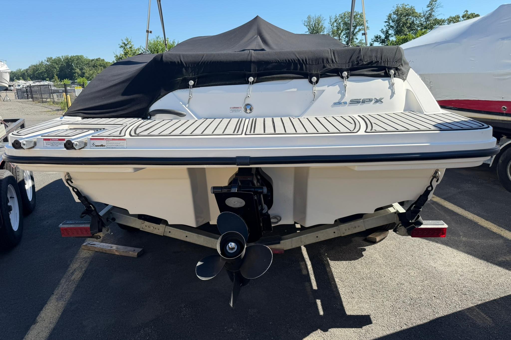 2016 Sea Ray SPX 210 boat with black cover, parked on a trailer.