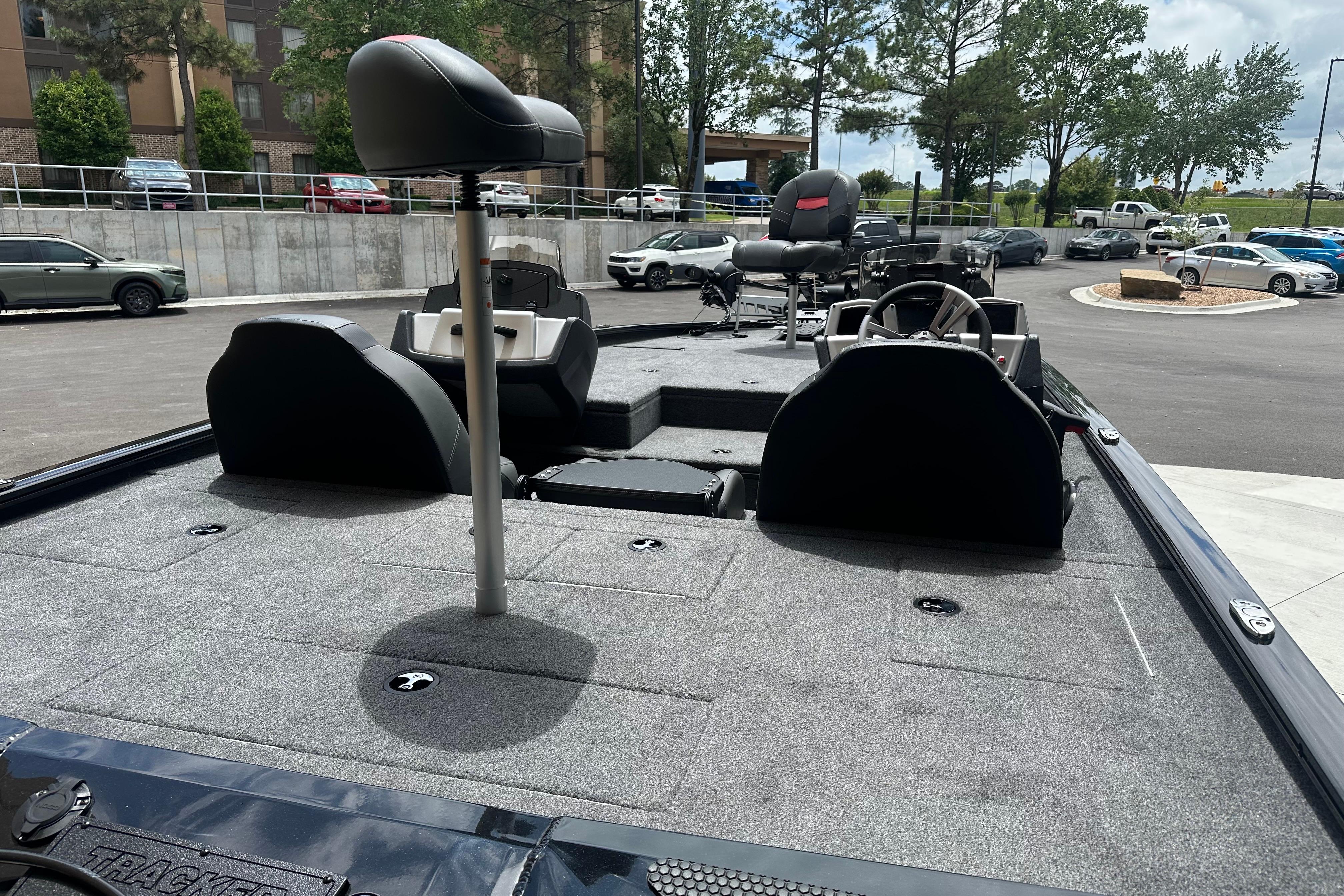 2025 Tracker Savage 215 boat interior with seating and steering wheel, parked outdoors.