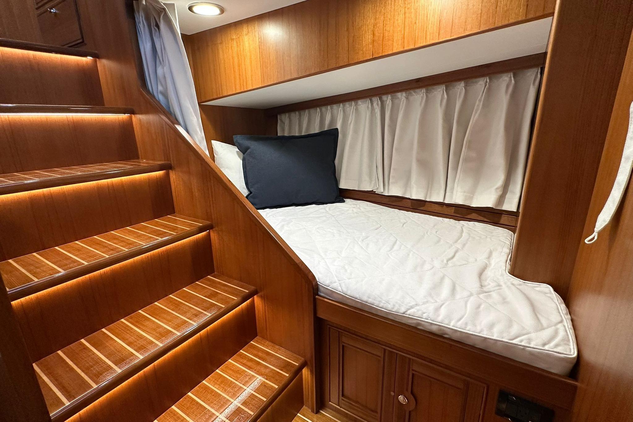 Luxurious cabin interior of 2023 Marlow Explorer 66E-CB with wooden stairs and cozy bed.