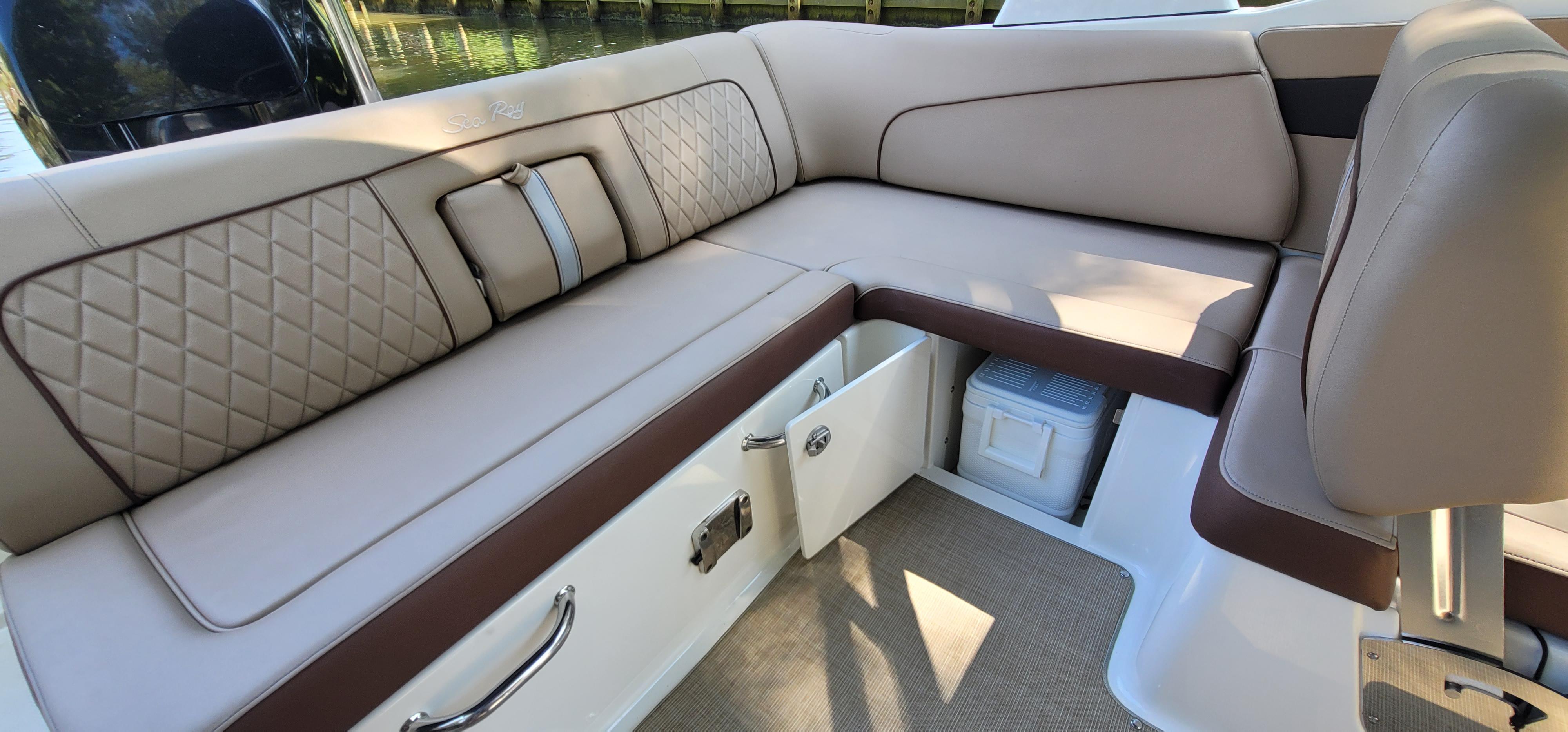 2017 Sea Ray SDX 240 Outboard boat interior with beige leather seating and storage compartments.