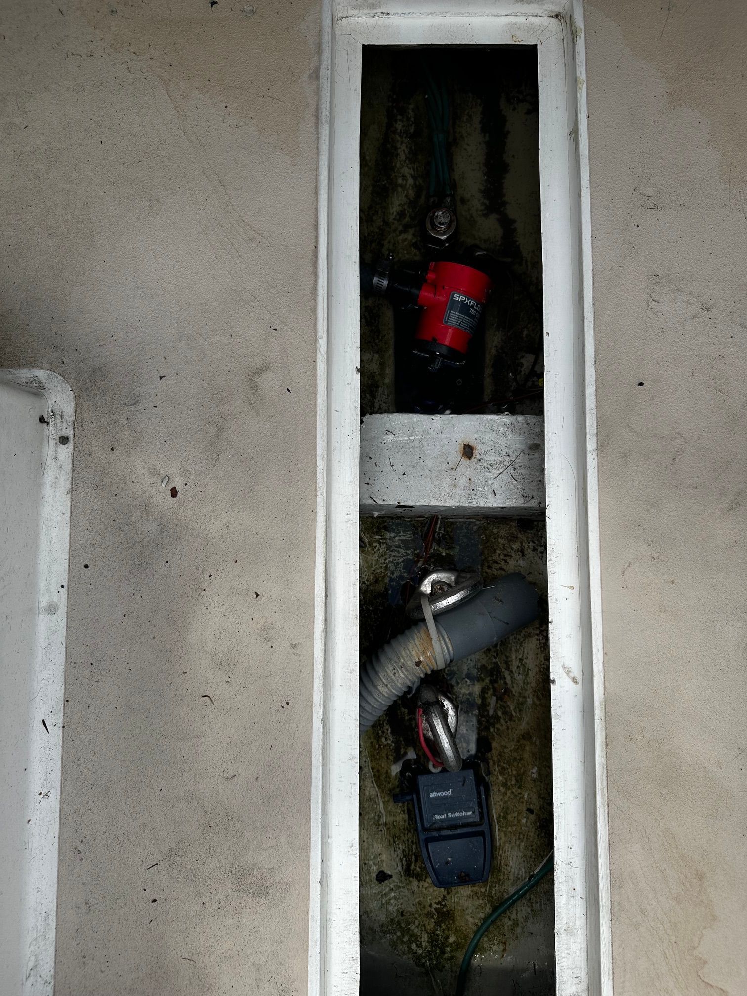 An open compartment in the boat reveals hoses and pumps.