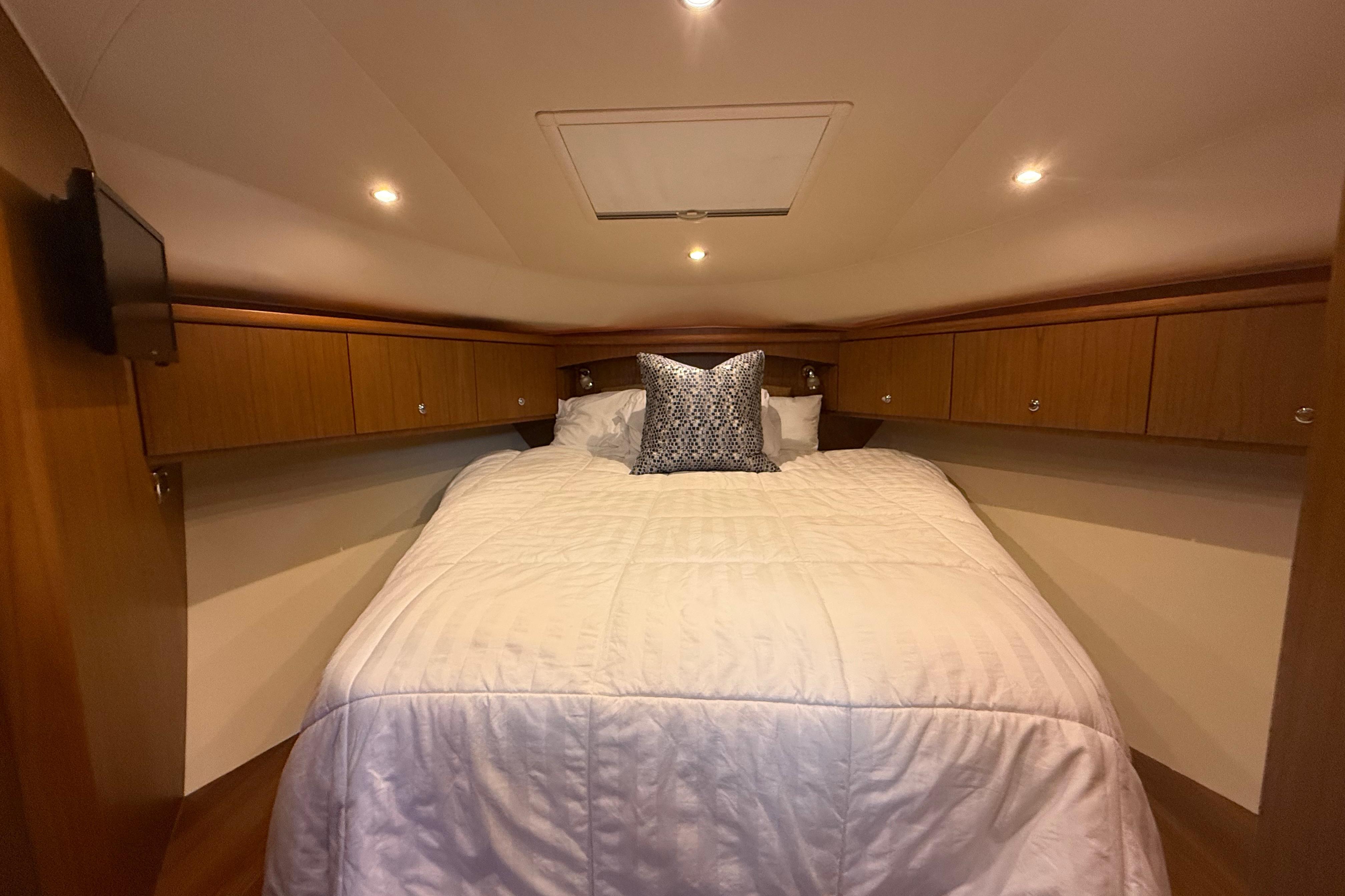 Luxurious cabin interior of 2014 Tiara Yachts 4500 Sovran with cozy bedding.