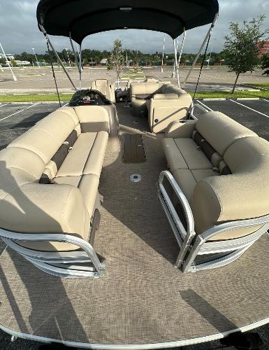 2023 Sun Tracker SportFish 22 XP3 pontoon boat with beige seating and canopy.