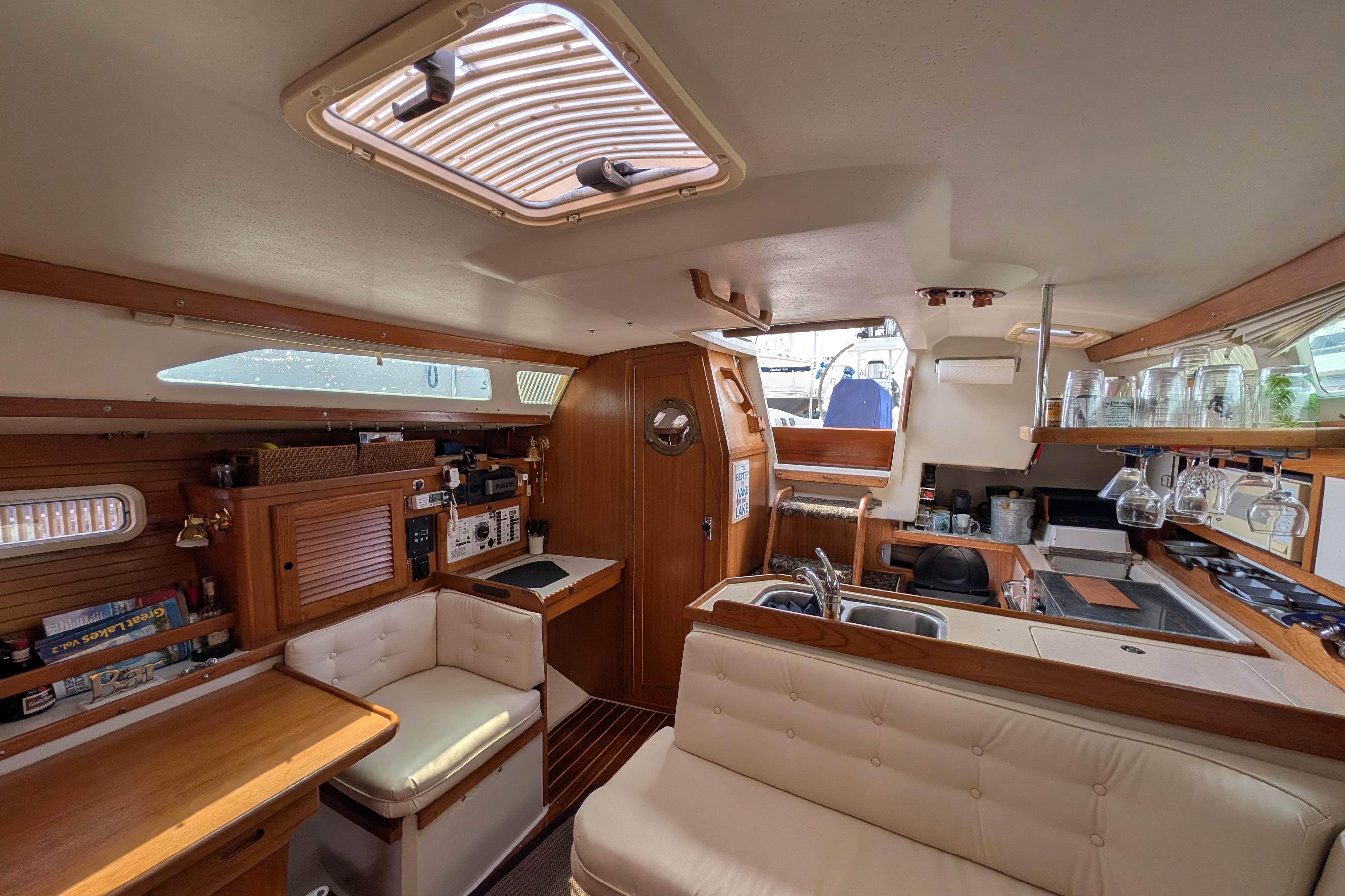 Interior of a 1995 Catalina 36 MkII sailboat, featuring a cozy dining and kitchen area.