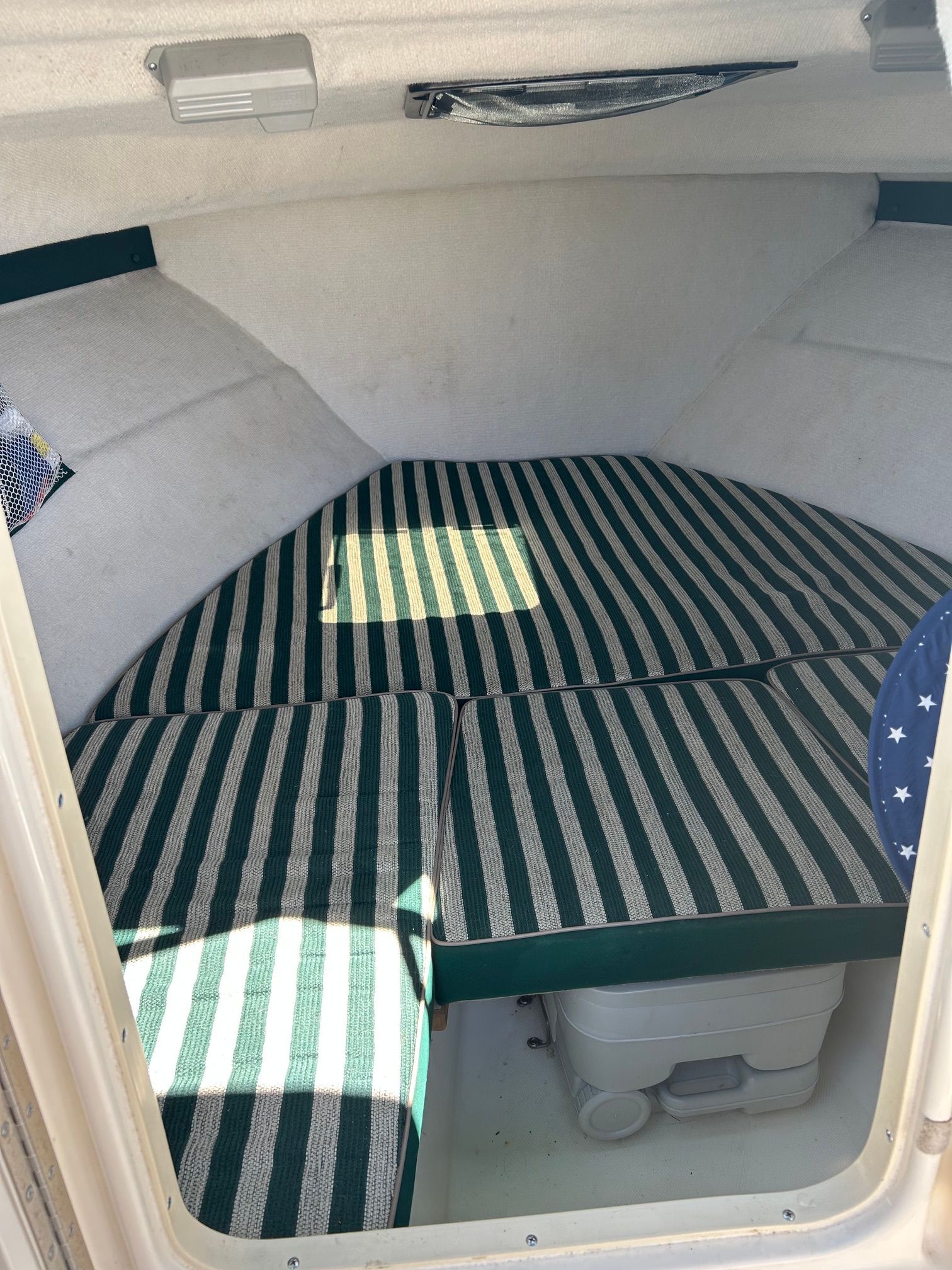 Interior of a 1999 Pursuit Denali boat with striped cushions.