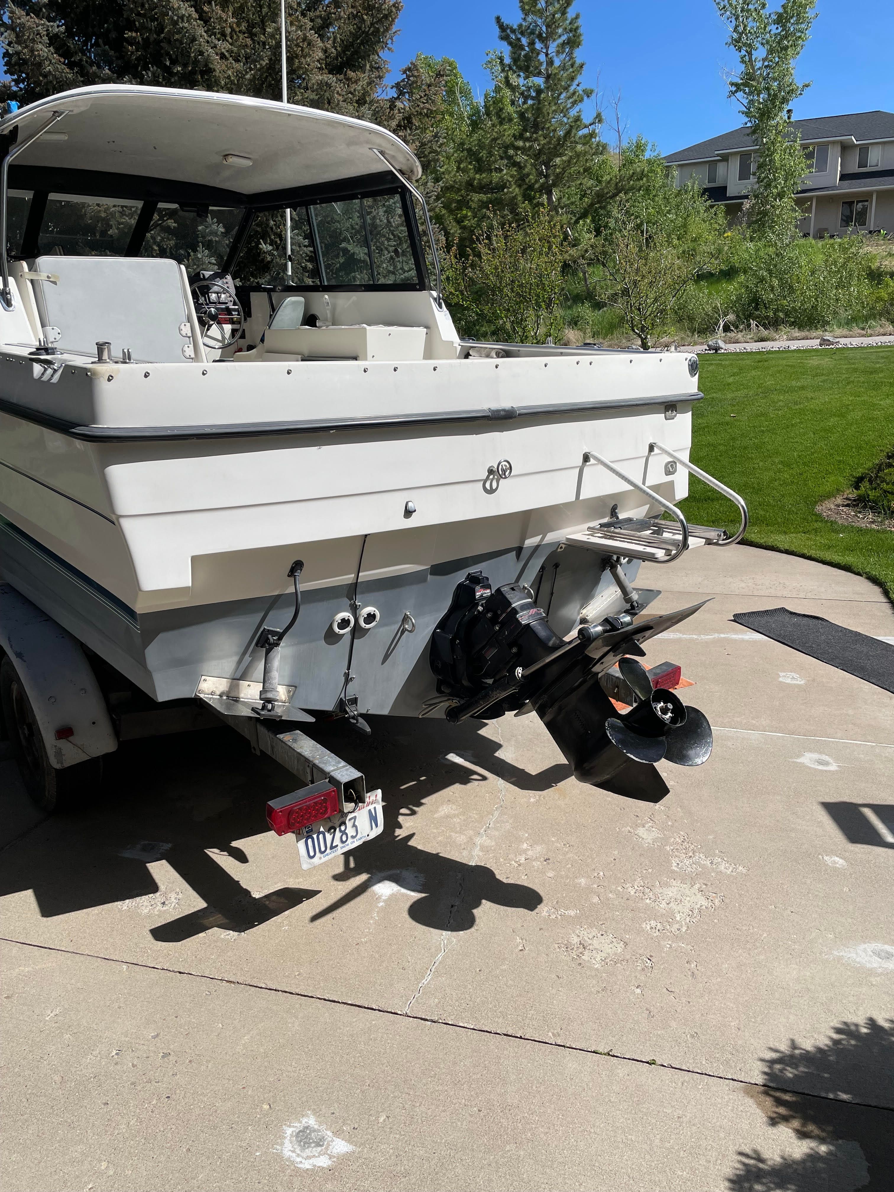 A 1991 Bayliner 2159 boat on a trailer in a driveway.