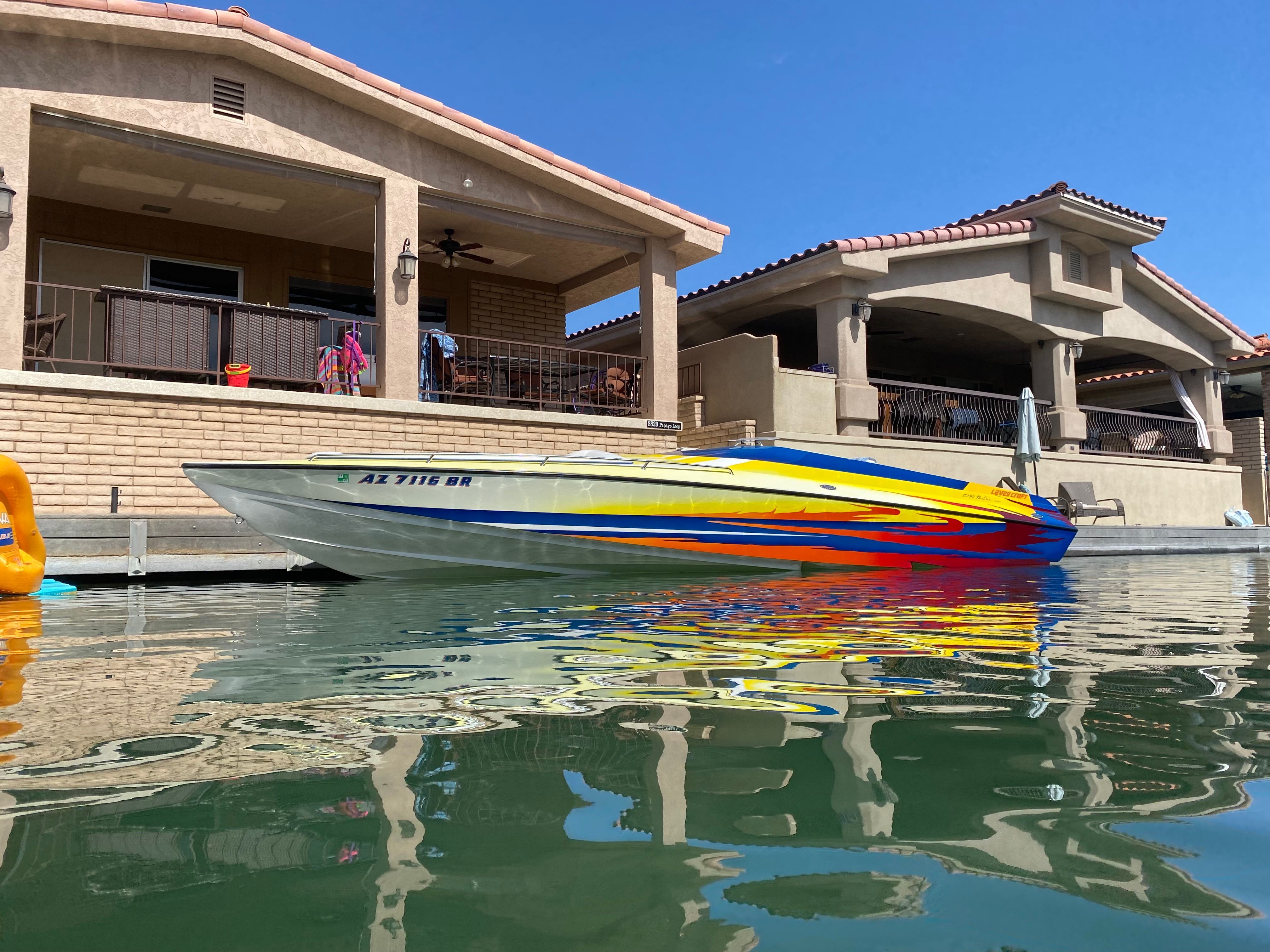 2002 Lavey Craft 2750 NUERA boat on water near a house.