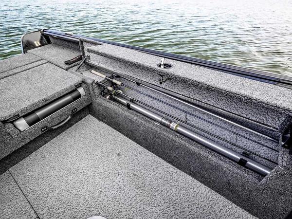 2026 Lund 1875 Impact XS boat interior with rod storage, on calm water.