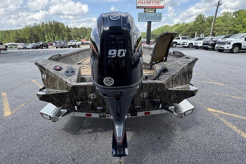 2026 Excel 183 Tomahawk boat with 90 HP engine on trailer in parking lot.