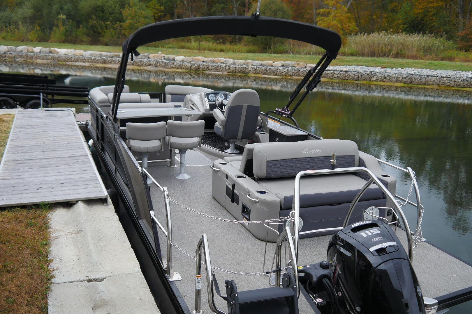 2023 Barletta CORSA 25UE pontoon boat docked by a serene lake.