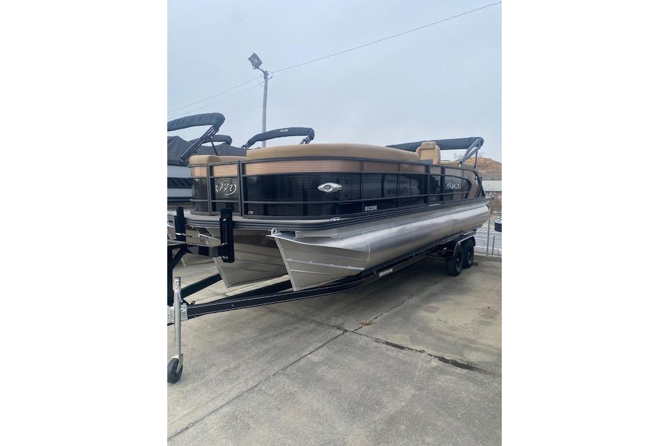 2026 Manitou 25 Encore RF VPII pontoon boat on trailer, parked outdoors.
