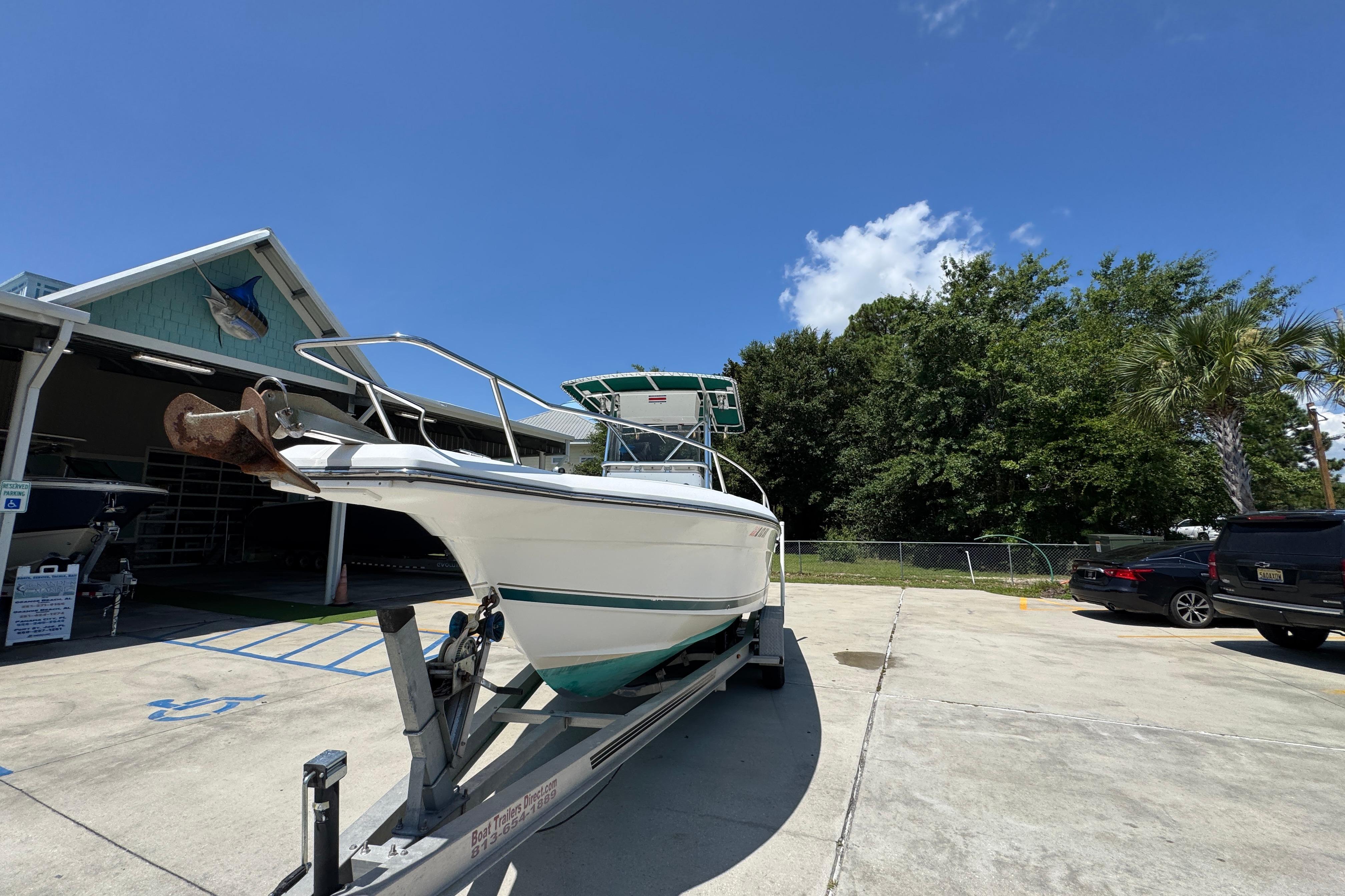 2000 Stamas 250 Tarpon boat on trailer, parked outdoors under clear blue sky.