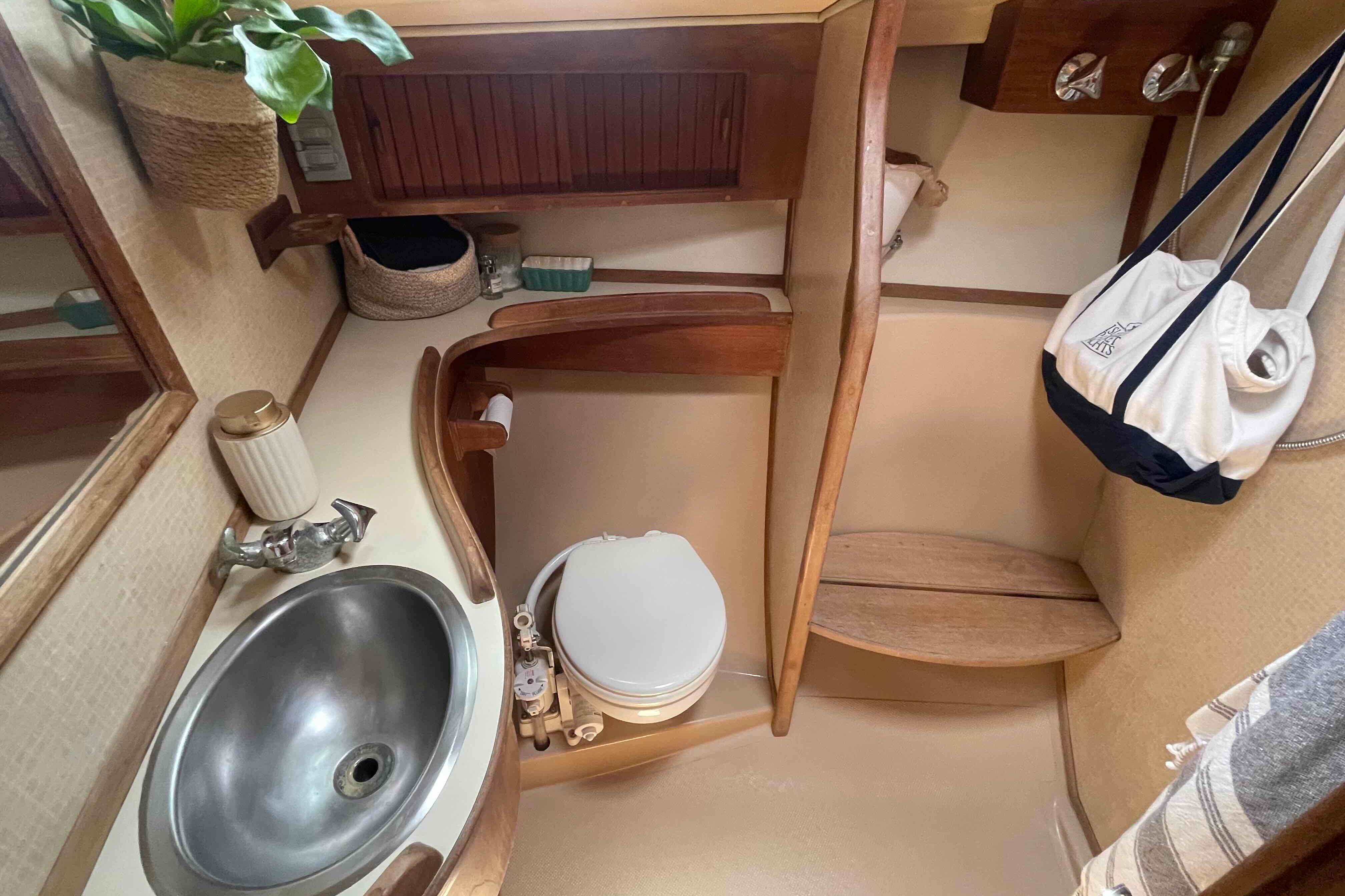 1989 Island Packet 35 yacht bathroom with sink, toilet, and wooden accents.