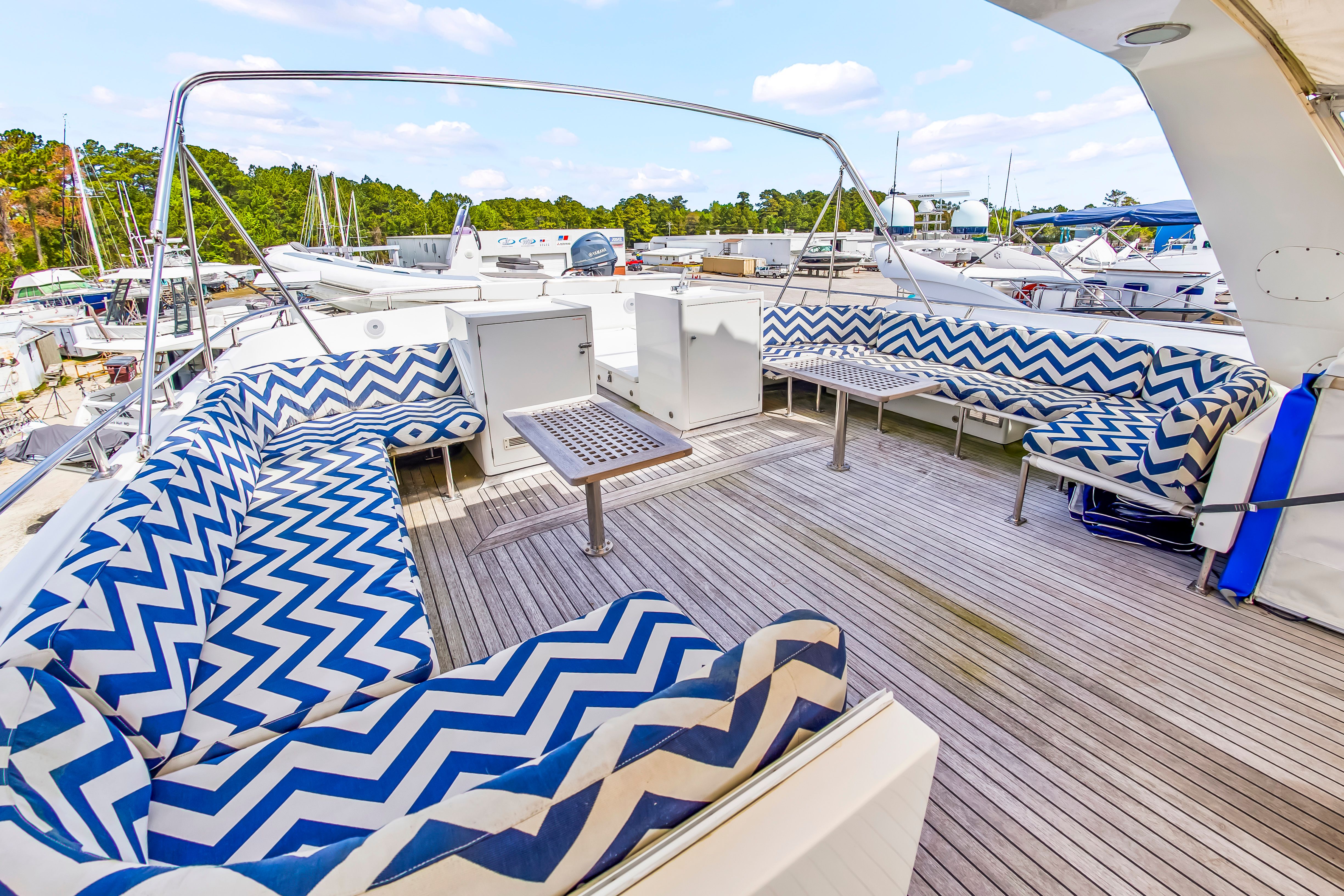 The image shows the deck of a 1987 Jongert 78 Motor Yacht with blue and white patterned cushions.