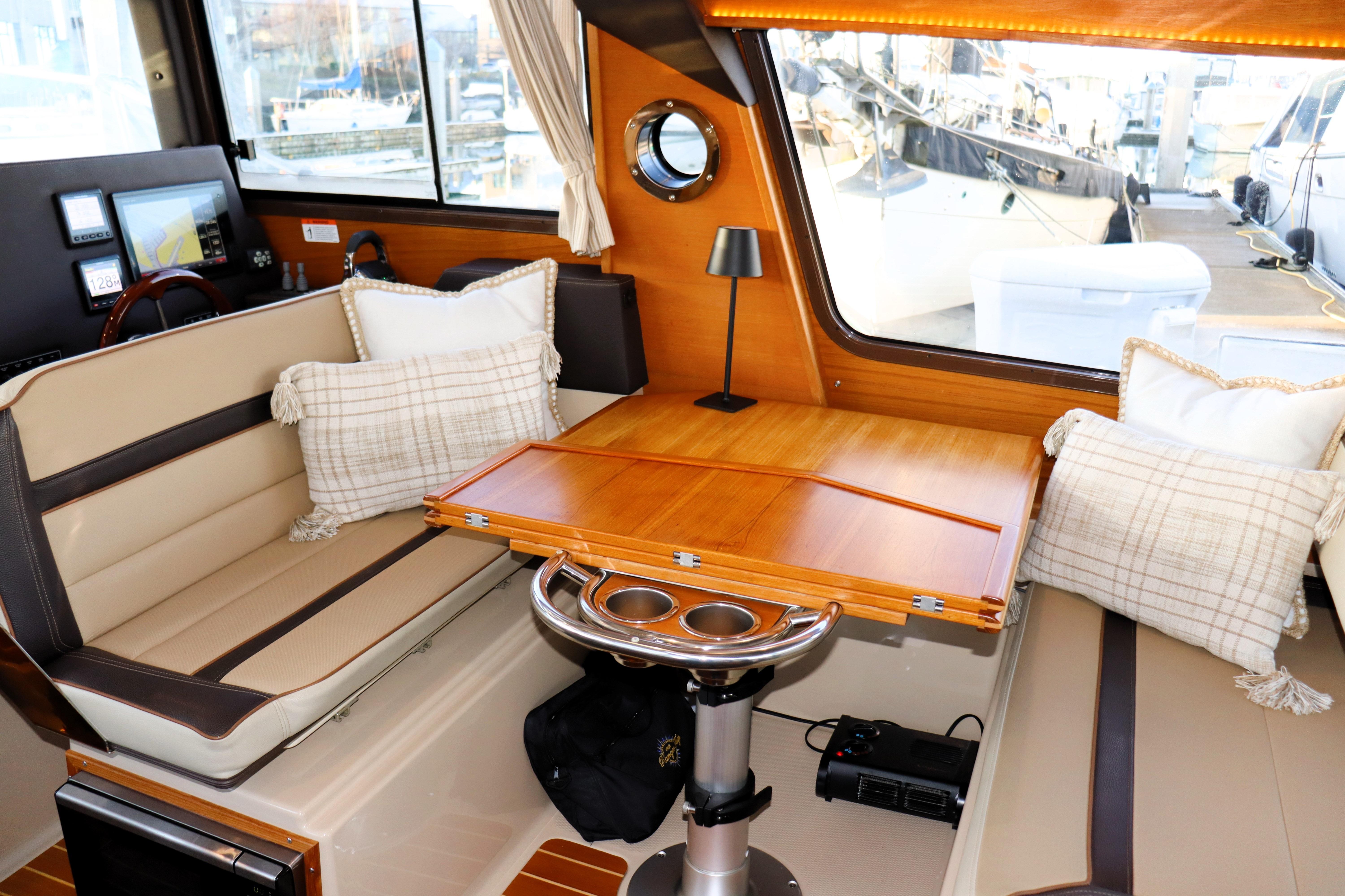 Interior of 2019 Ranger Tugs R-29 CB with cozy seating and wooden table.