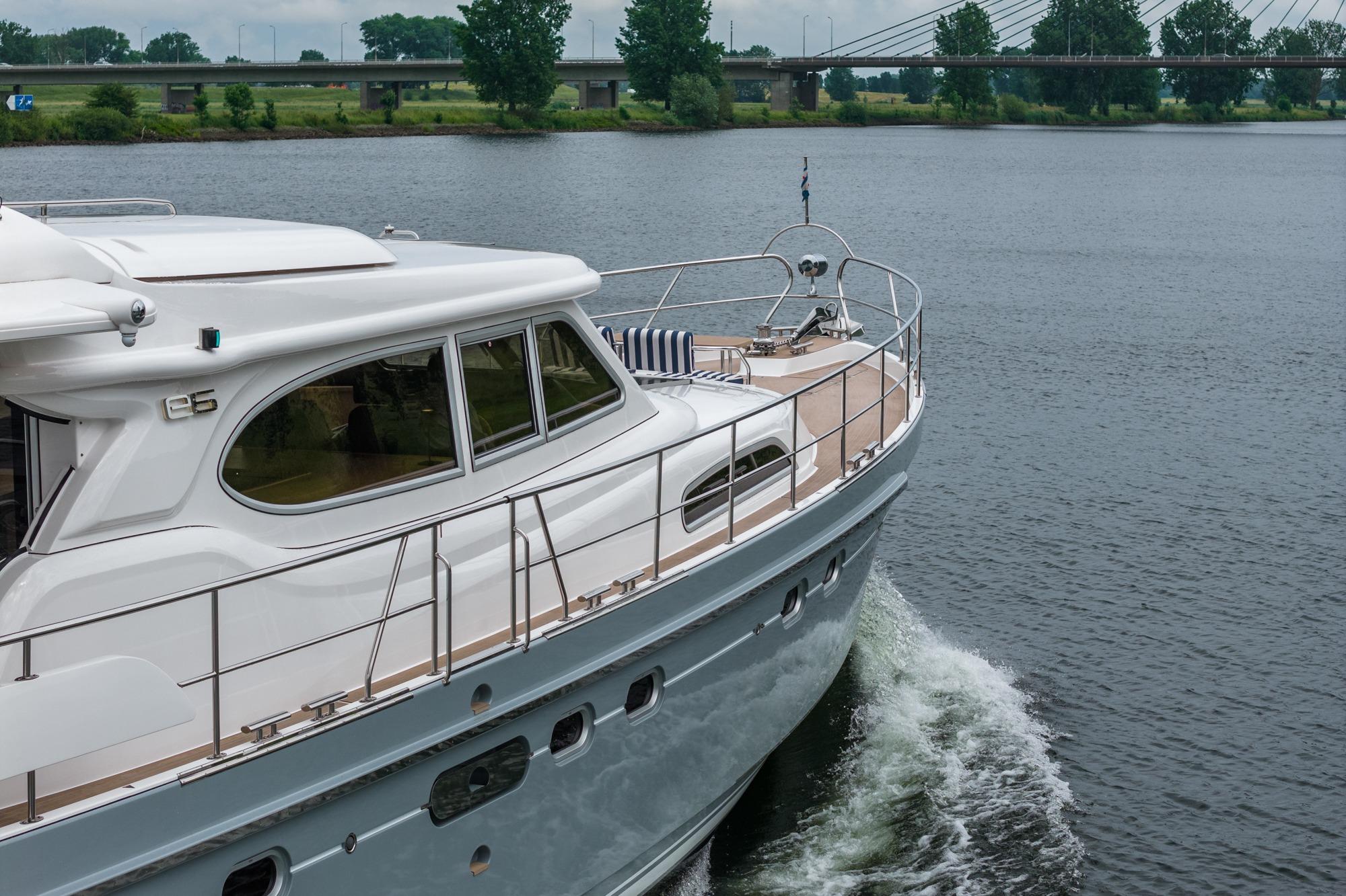 2025 Elling E6 yacht cruising on a river near a bridge.