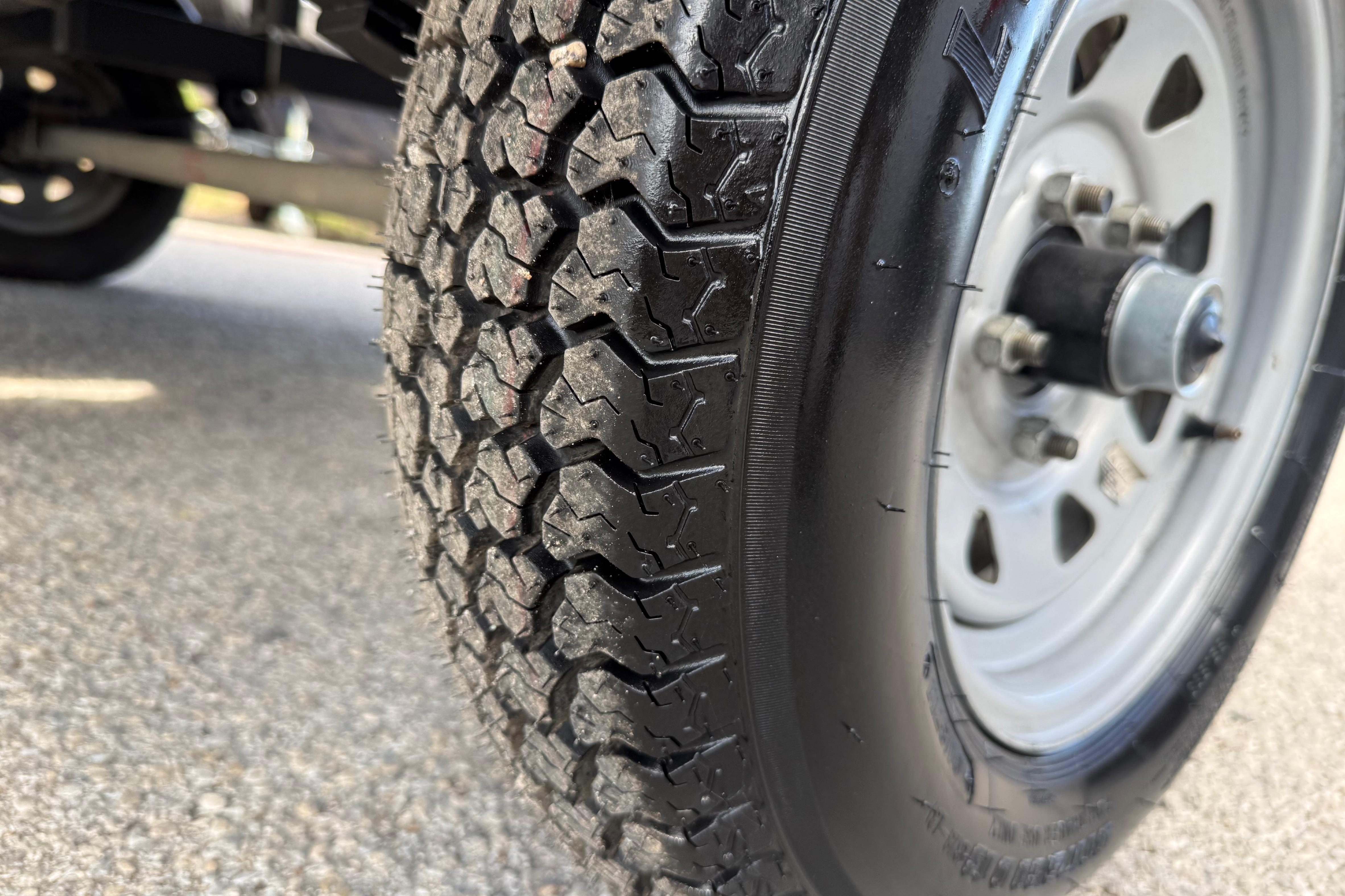 Close-up of a 2020 Lowe Roughneck 2070 Big River trailer tire on pavement.