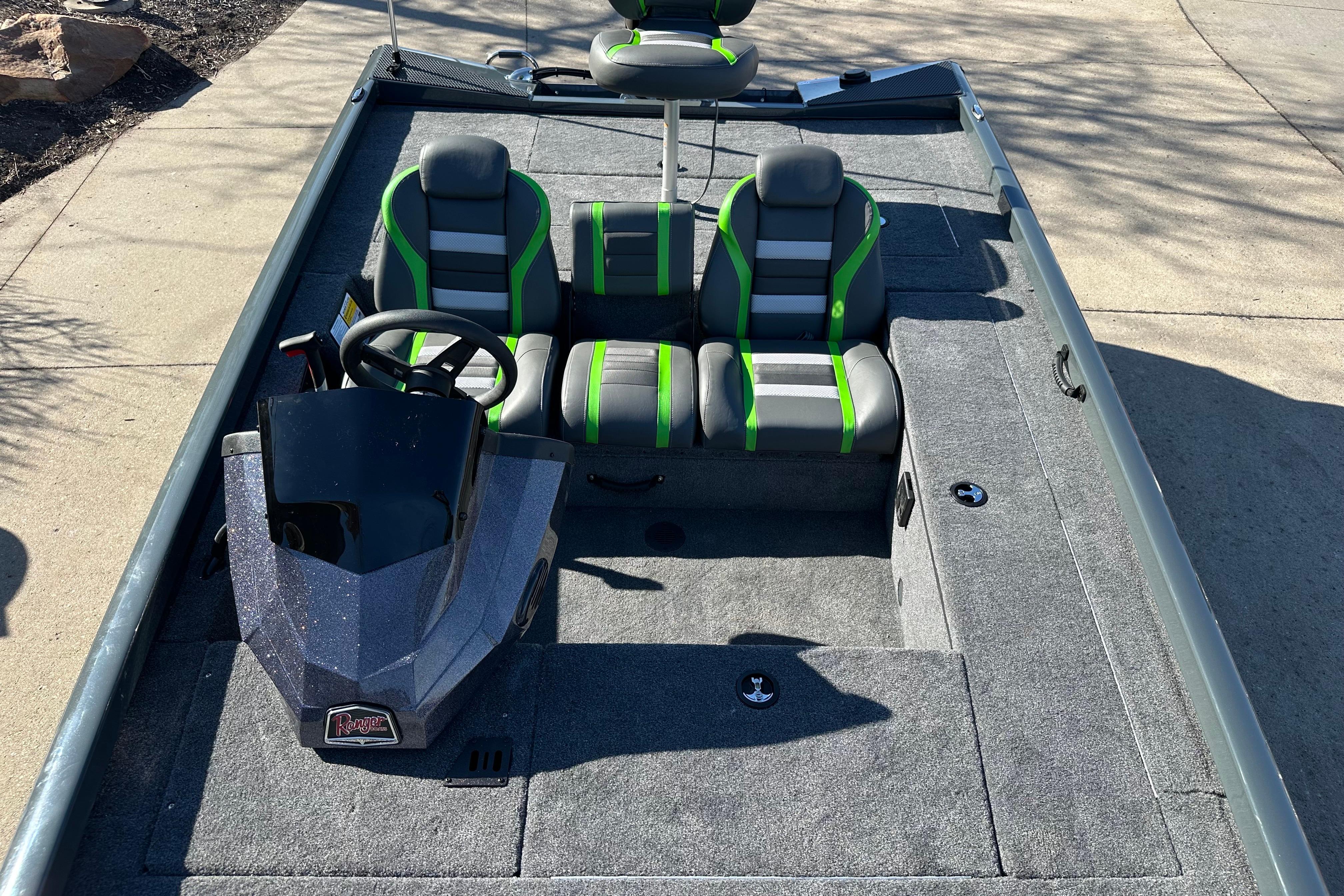 2026 Ranger RT178C boat interior with gray and green seating, steering console, and carpeted flooring.