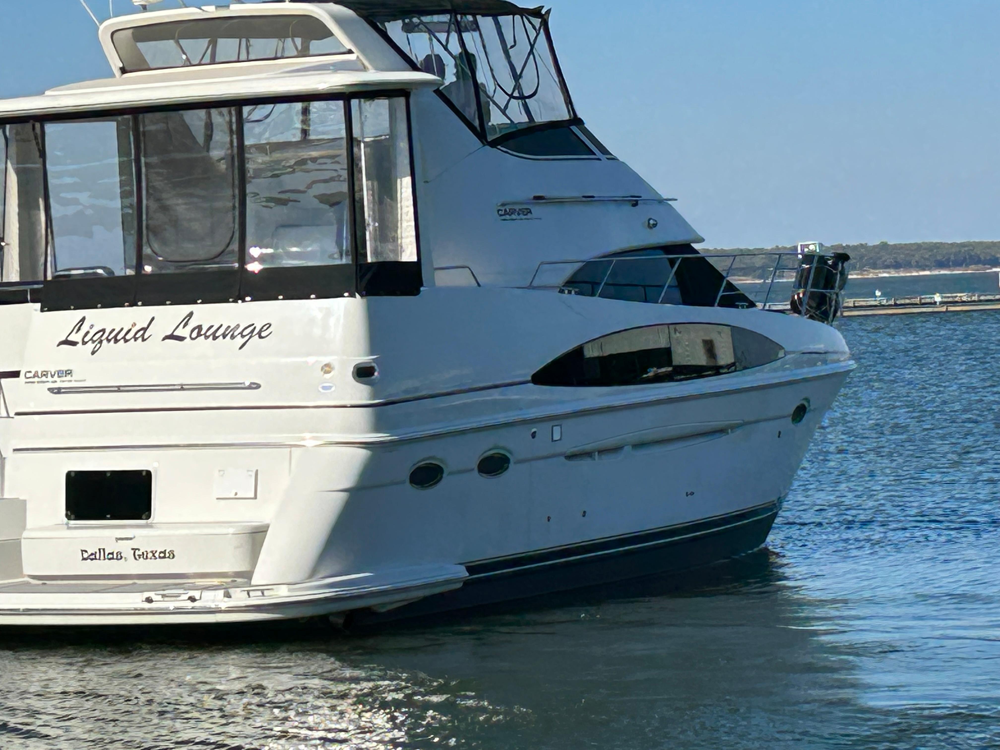 Carver 396 yacht named "Liquid Lounge" docked in calm waters, 2000 model.