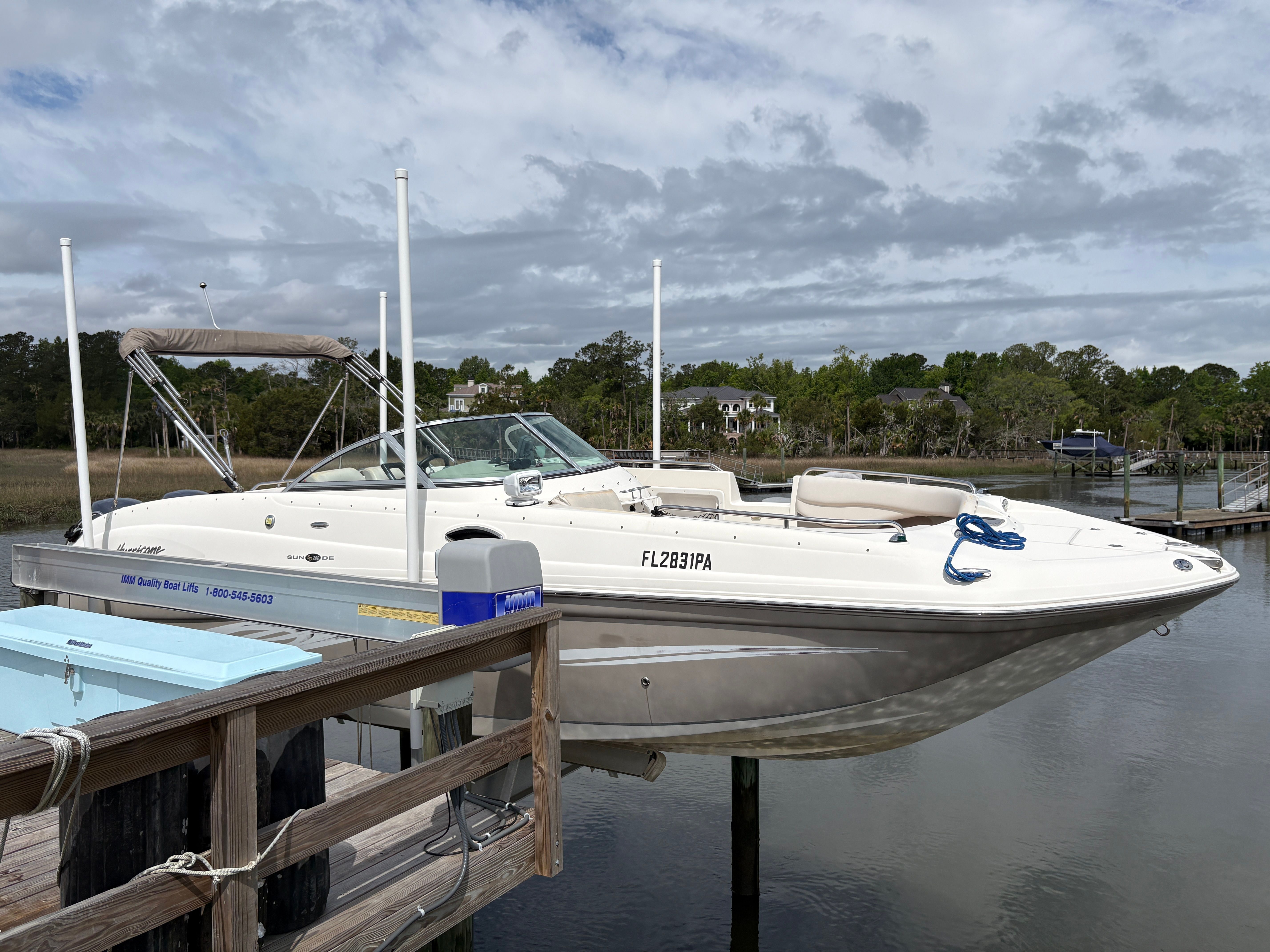 2009 Hurricane SUN DECK 260 boat docked, cloudy sky.