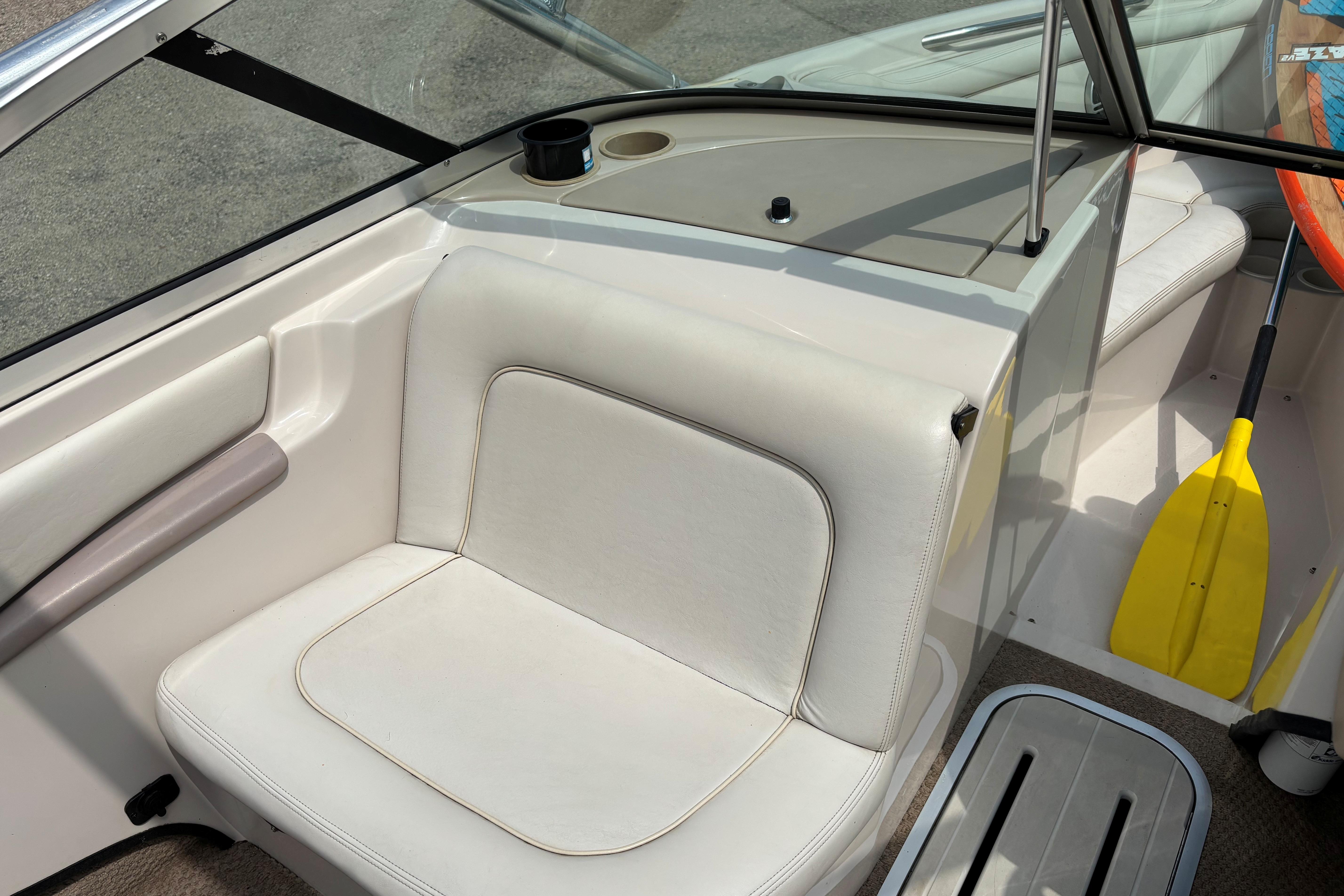 Interior of 1999 MasterCraft 205 PRO STAR boat with white seating and yellow paddle.