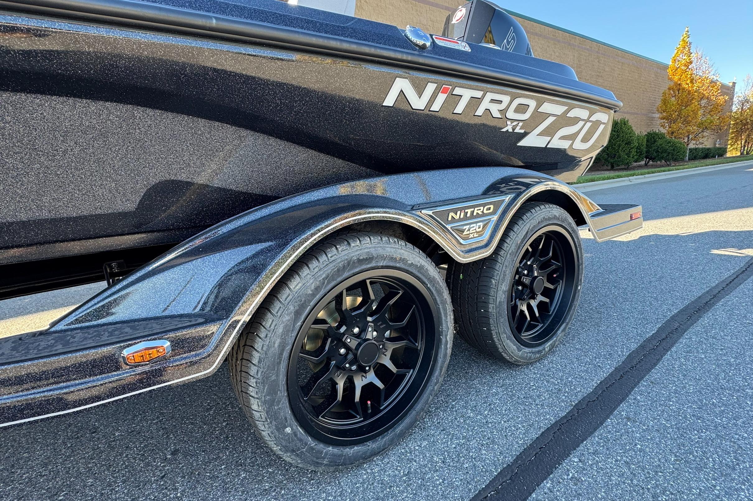 2026 Nitro Z20 XL Pro boat trailer with sleek black wheels on a sunny street.