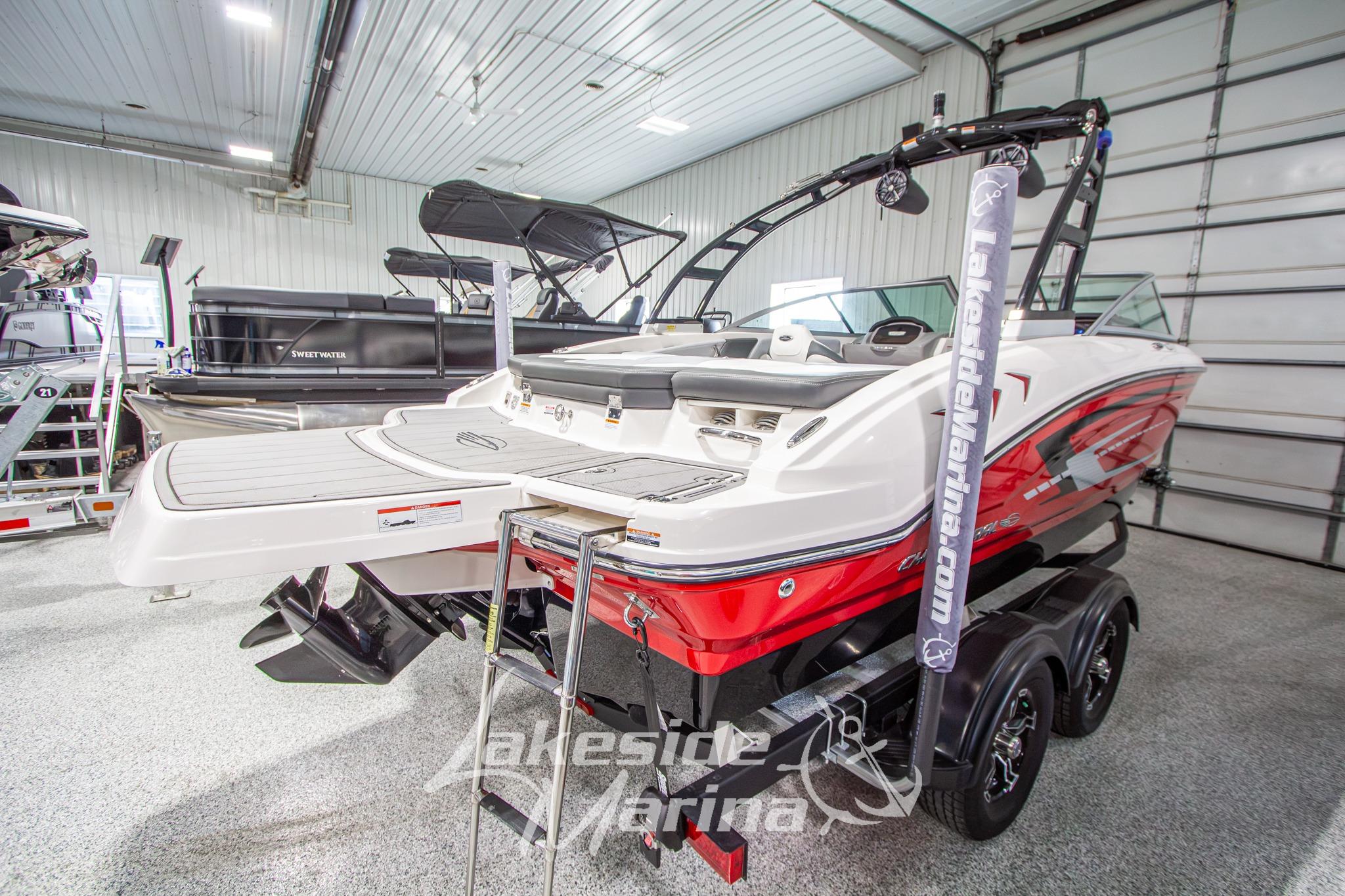 2022 Chaparral 21 SSi boat in showroom, featuring sleek red and white design.