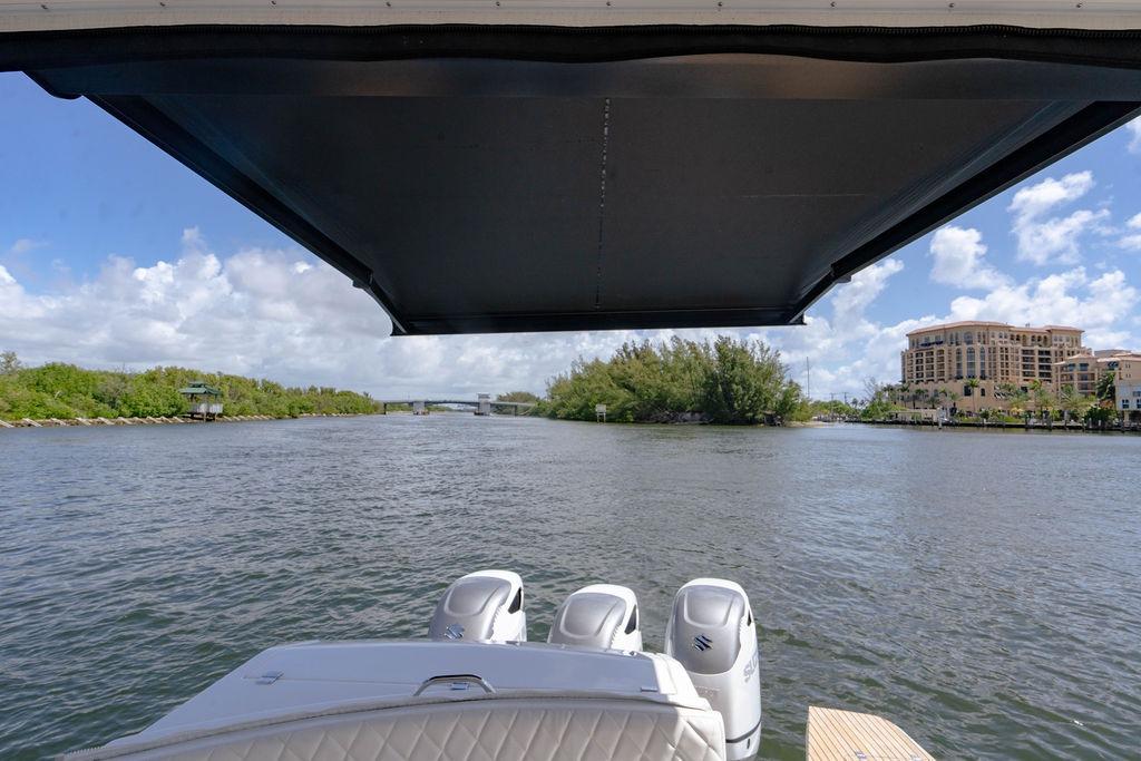 View from a 2022 Schaefer 400 Sport boat, overlooking a scenic waterway with lush greenery.
