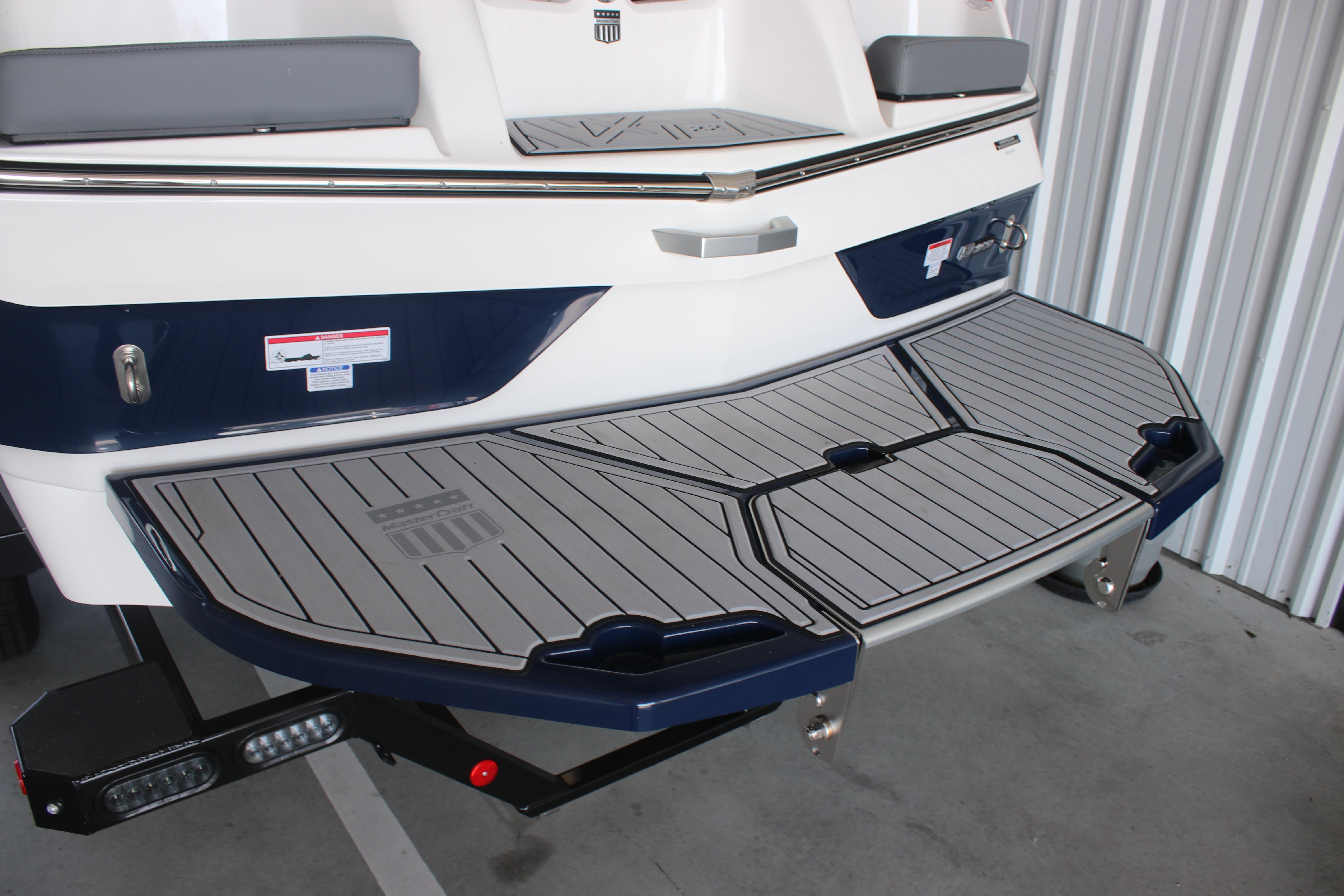 2025 MasterCraft XT22 boat with sleek swim platform in a storage facility.